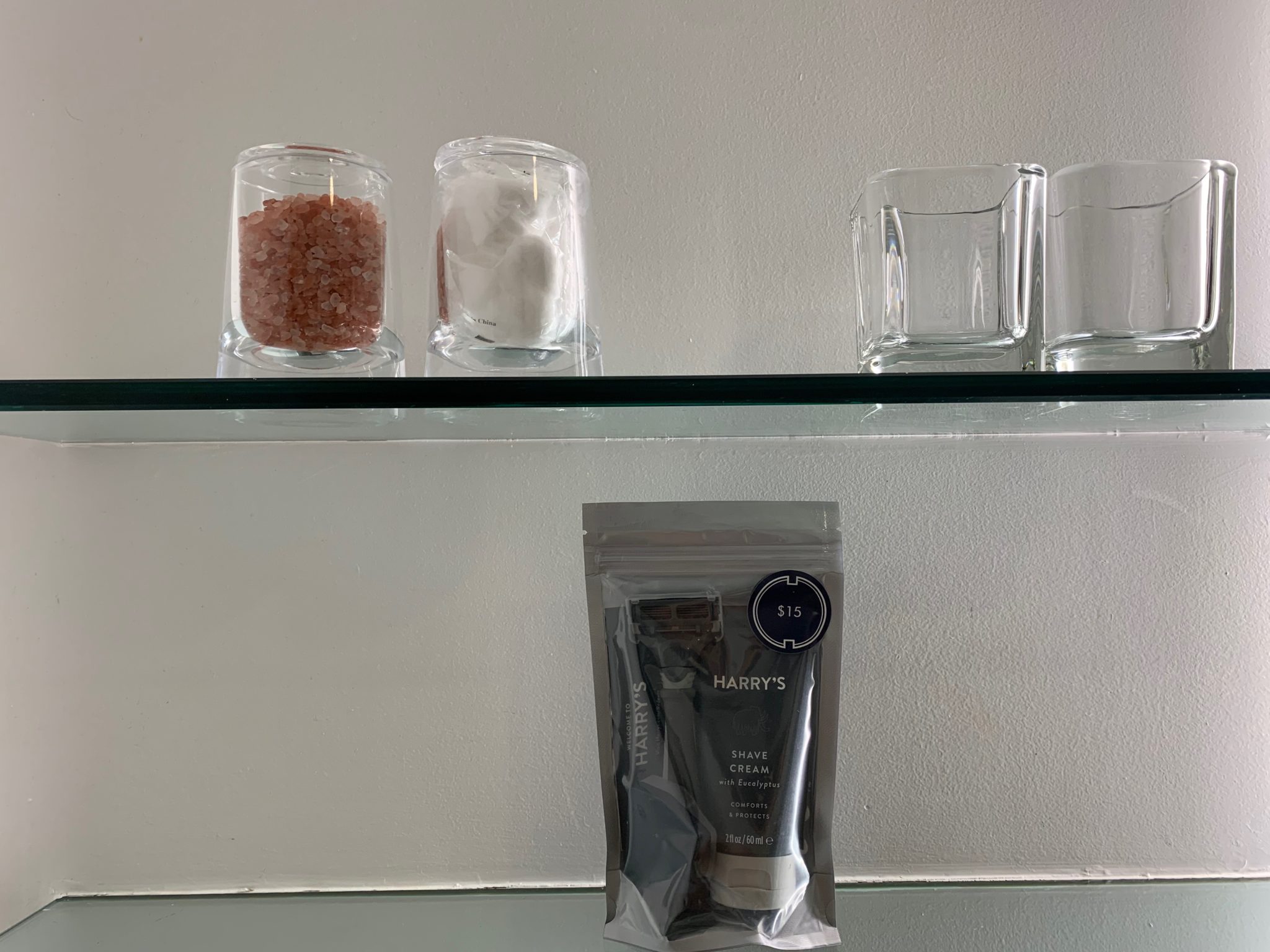 a shelf with candles and a bag of liquid
