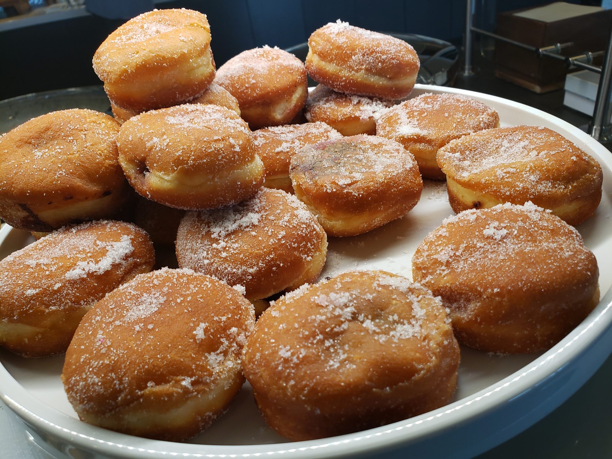 a plate of donuts with sugar on it