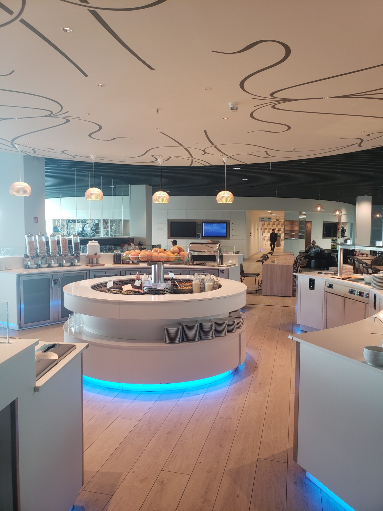 a large white kitchen with a circular counter and a blue light