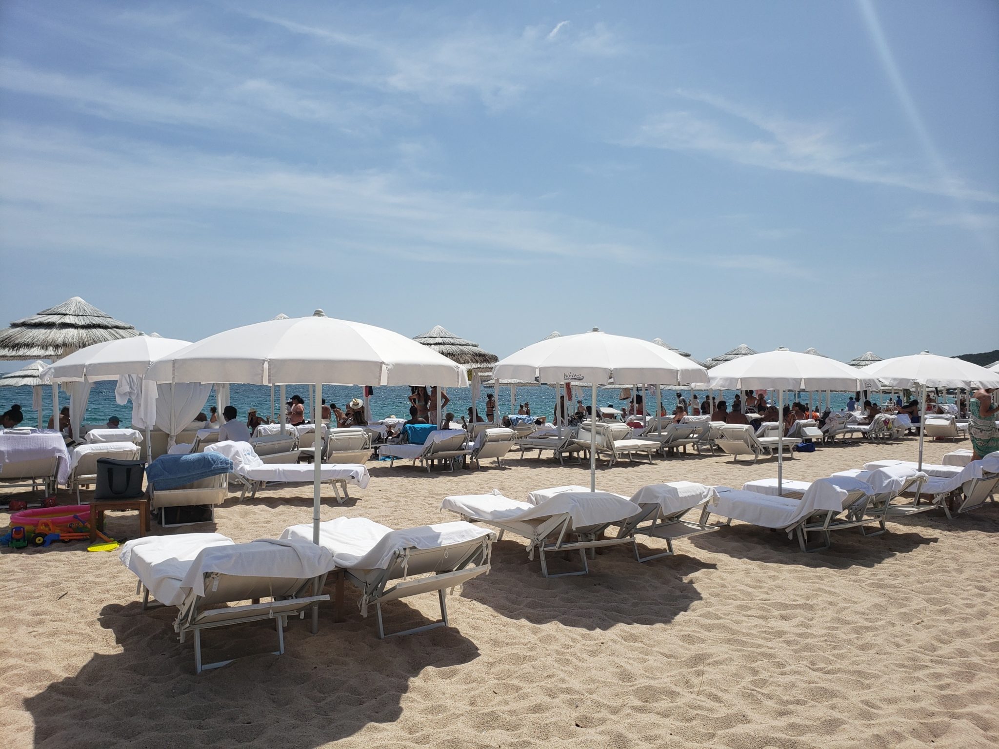 a group of lounge chairs and umbrellas on a beach