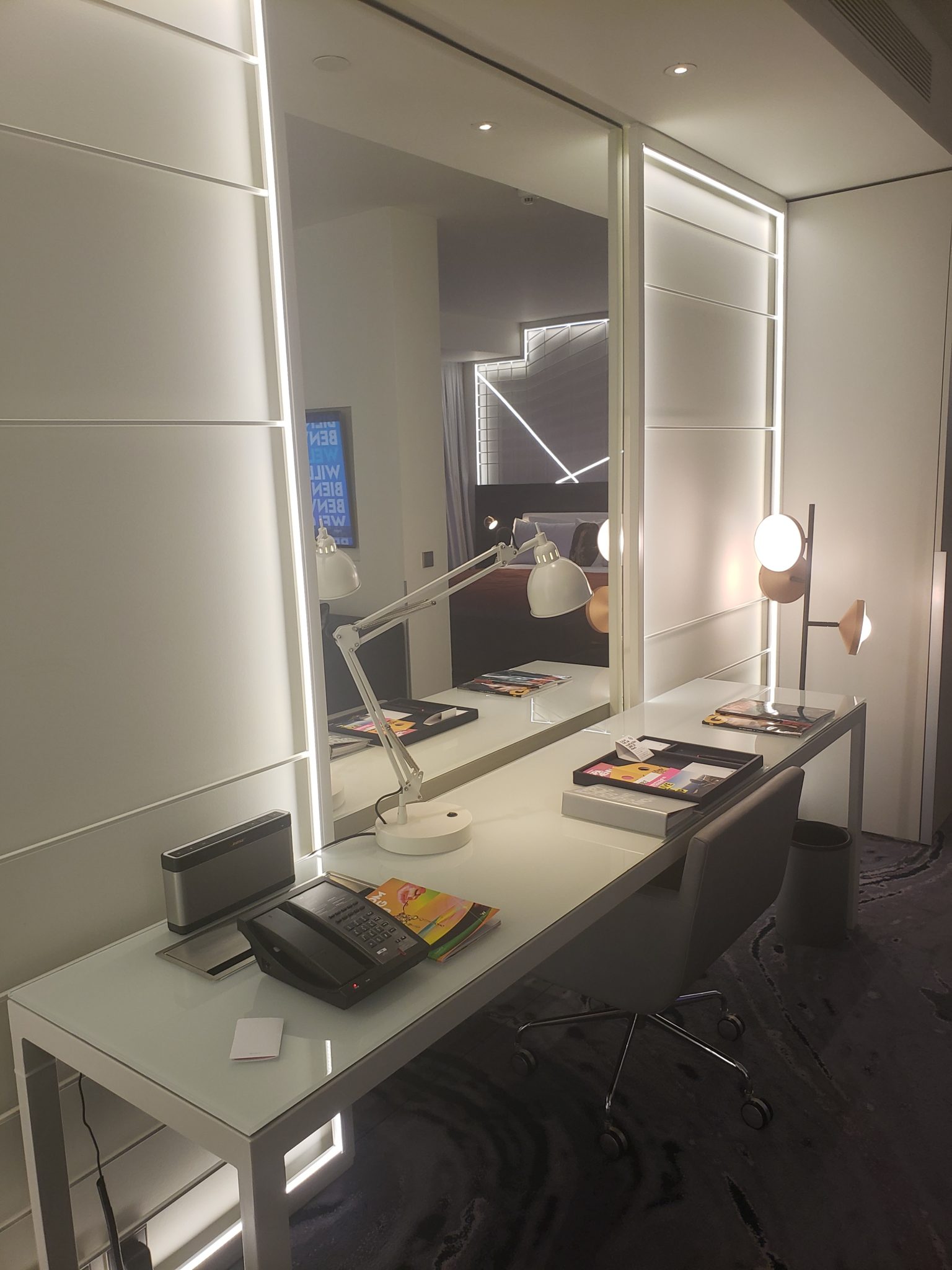 a desk with a mirror and a telephone on it