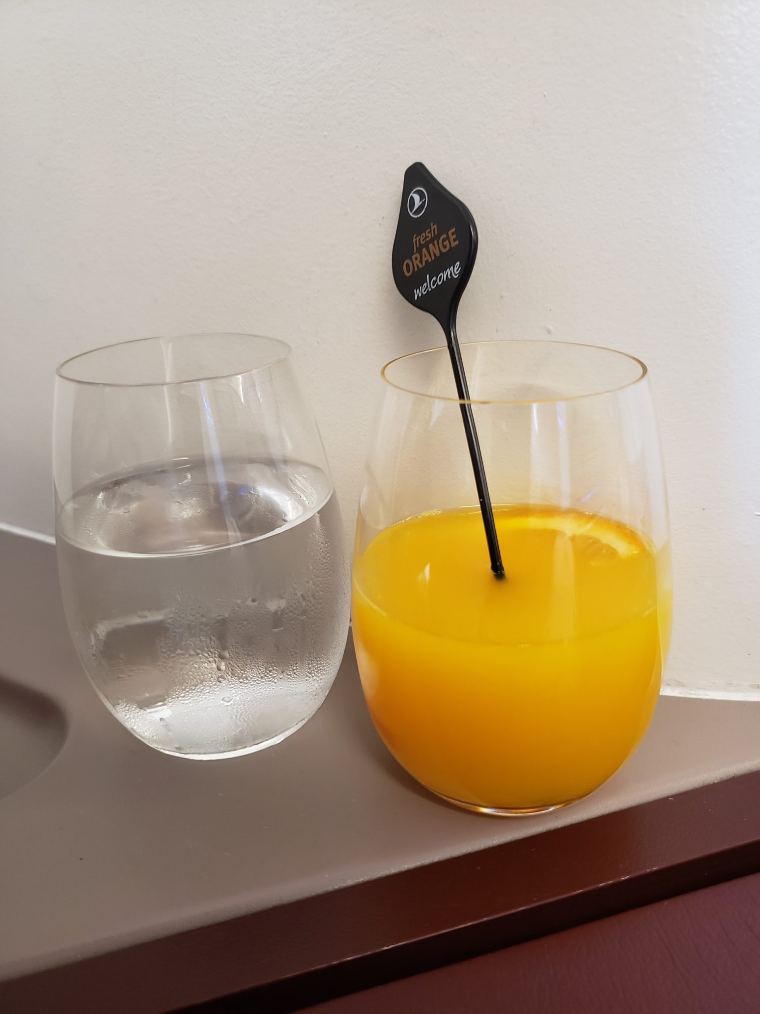 a glass of orange juice next to a glass of water