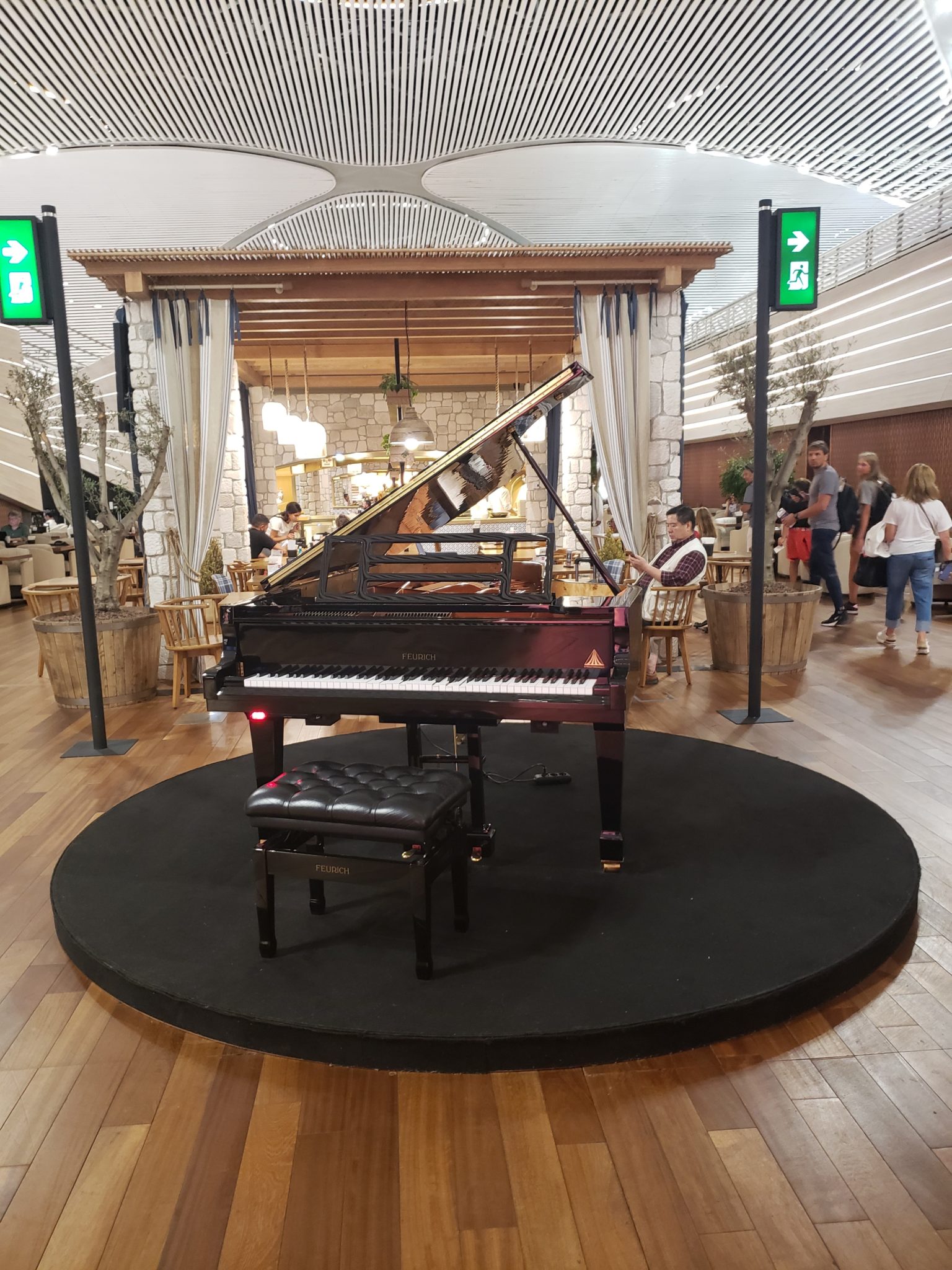 a piano on a circular platform in a room with people
