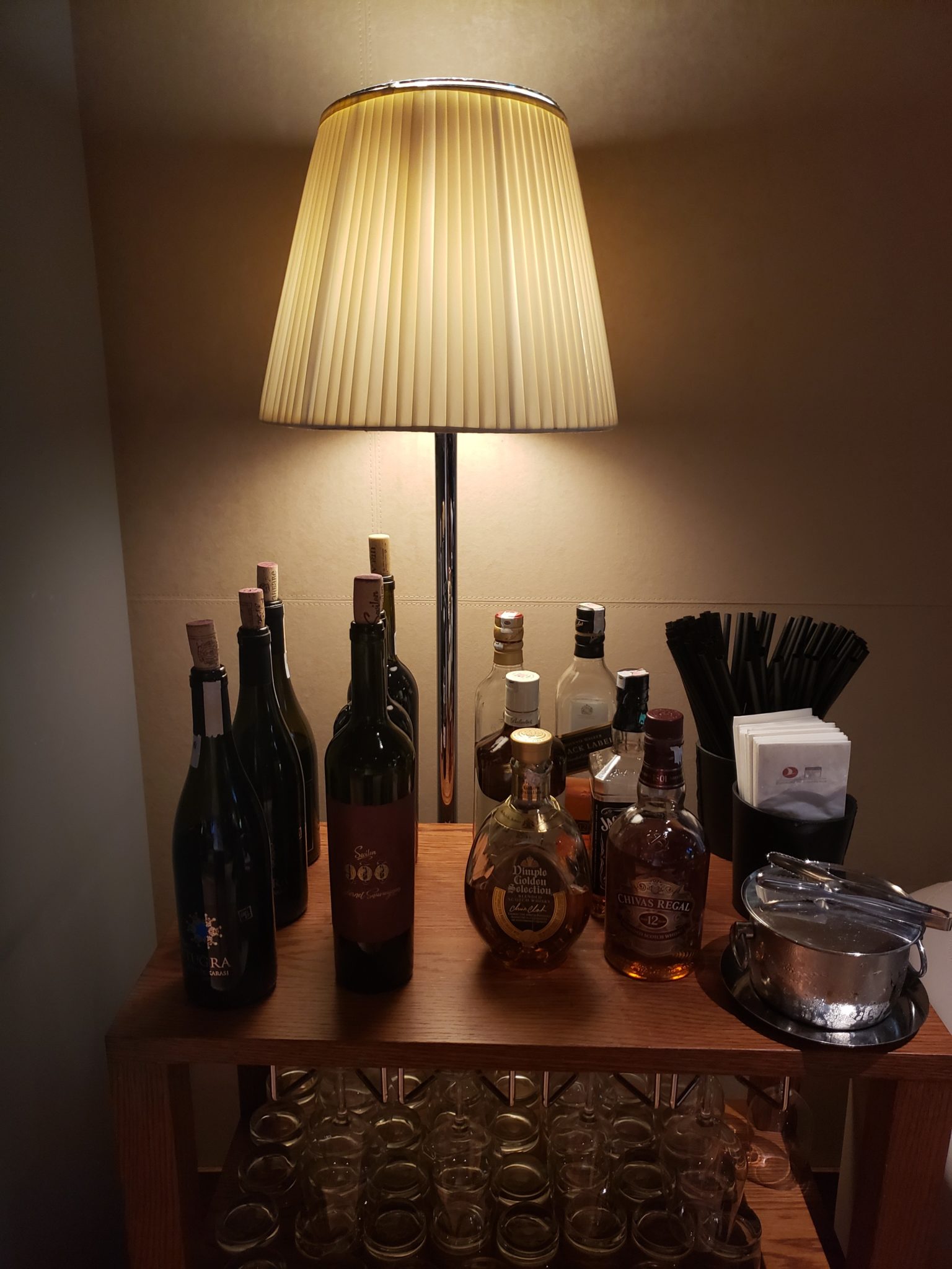 a table with a lamp and bottles of alcohol