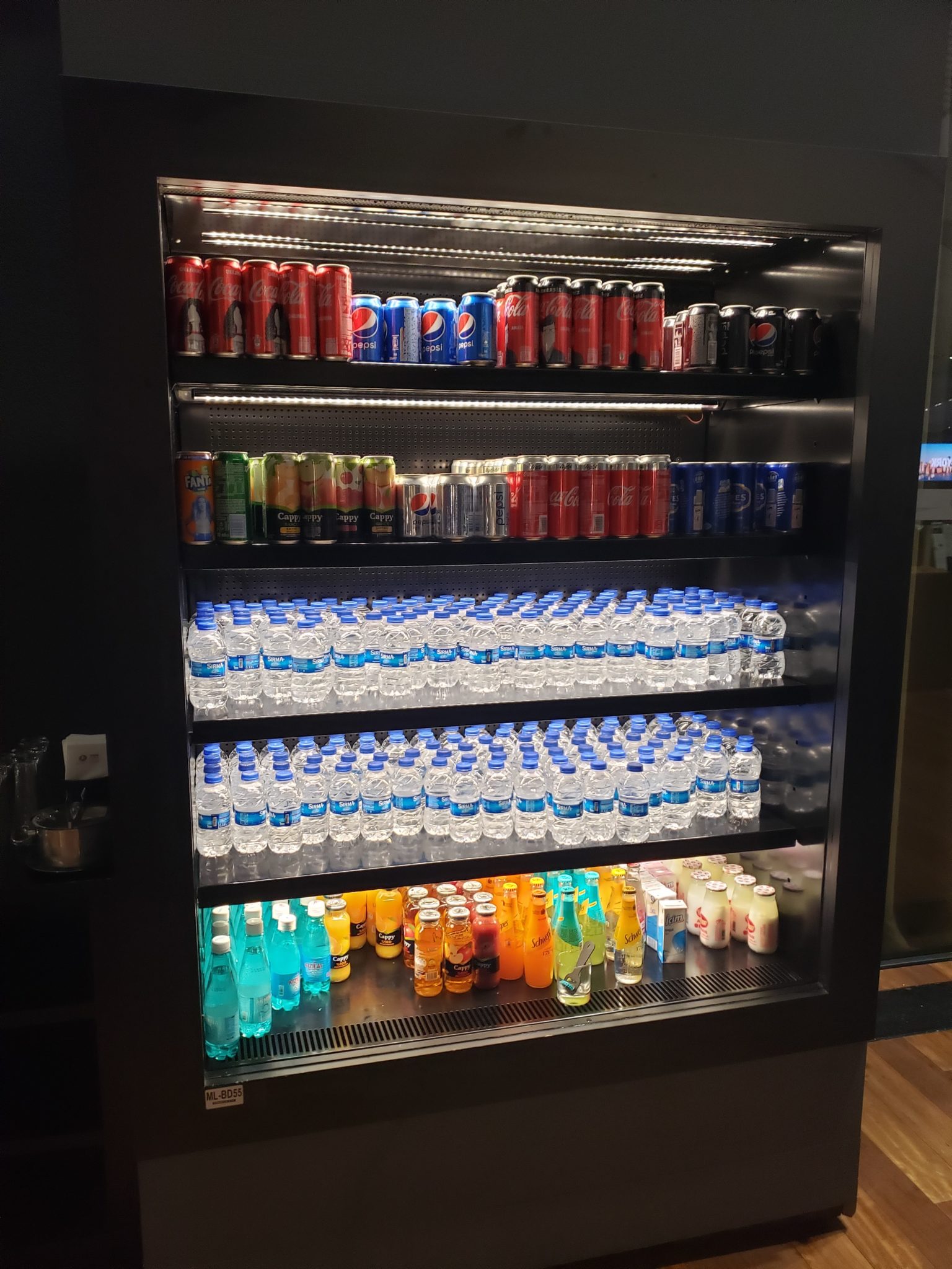 a display case with drinks and cans