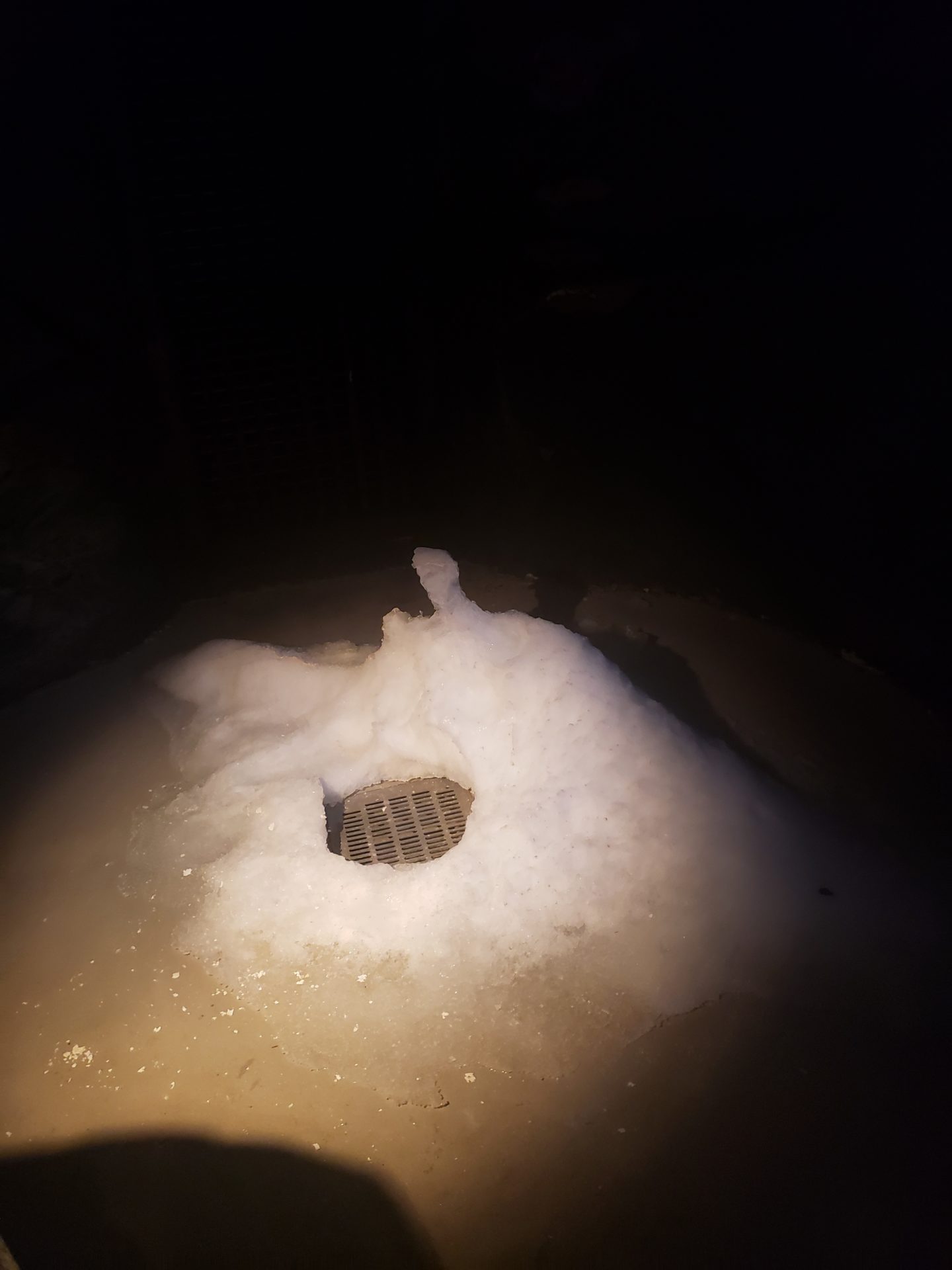 a drain in a hole in the snow