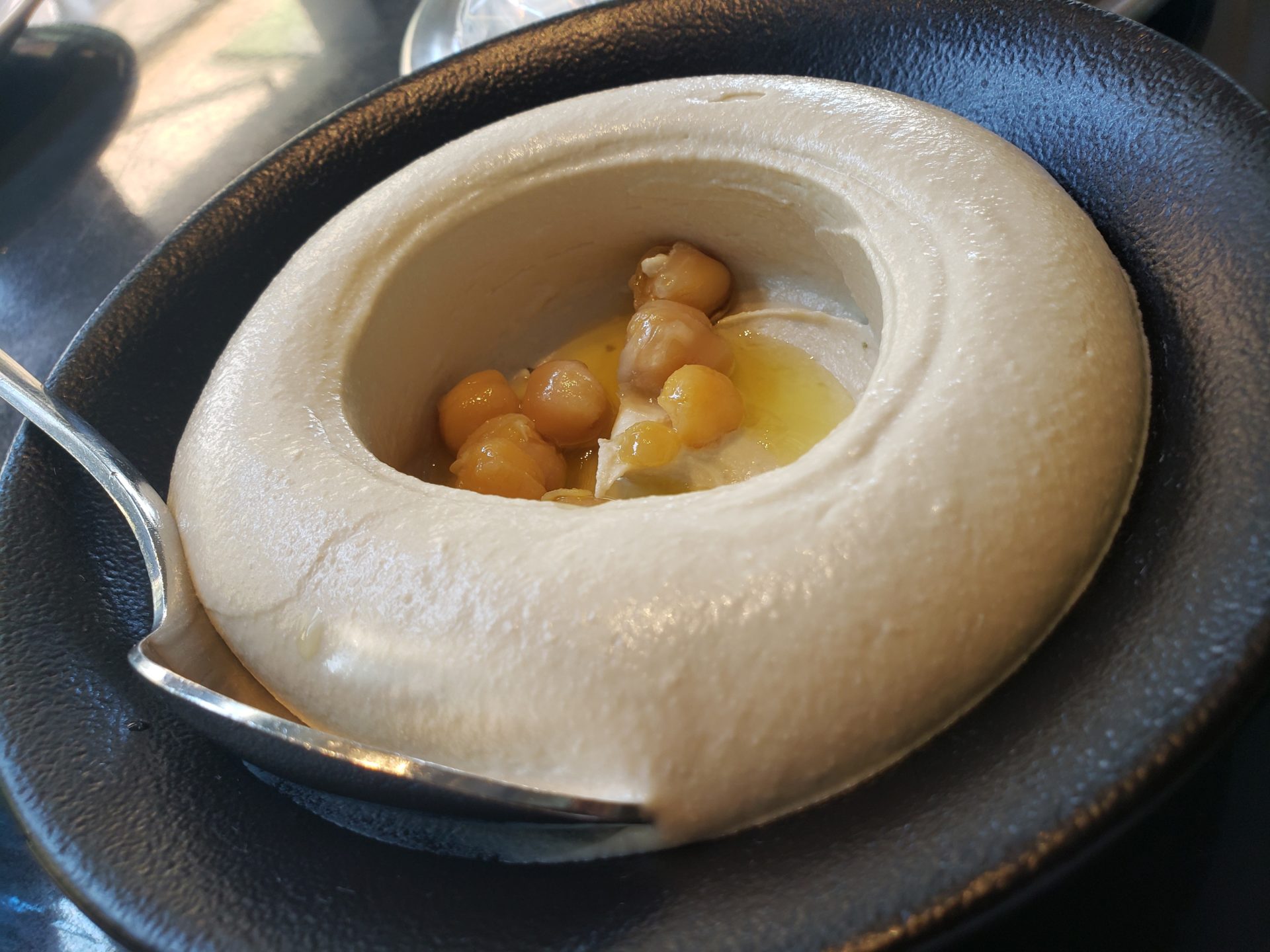 a bowl of hummus with a spoon