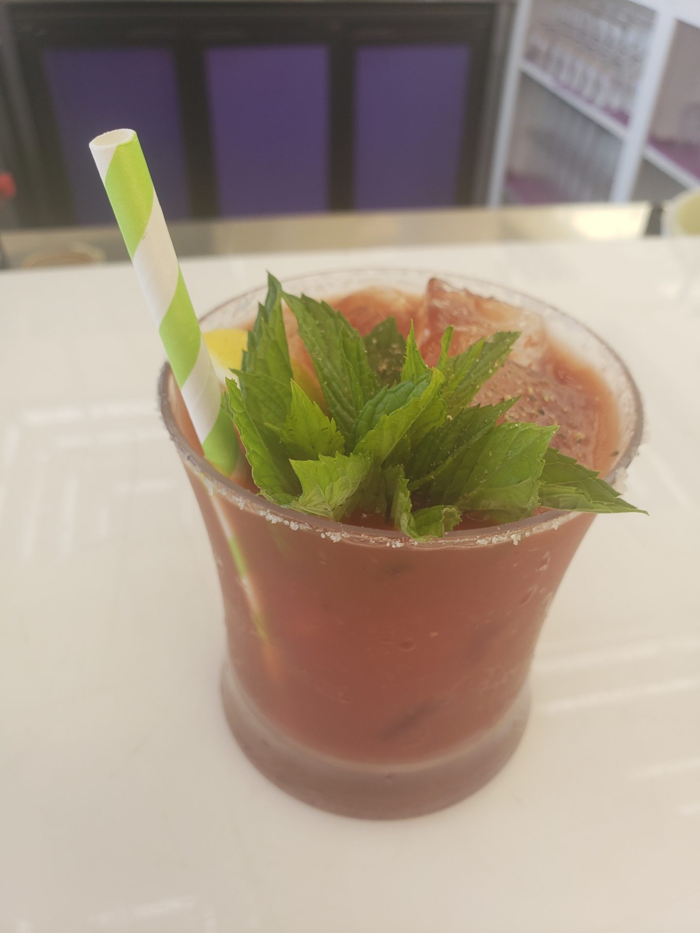 a drink with a straw and mint leaves