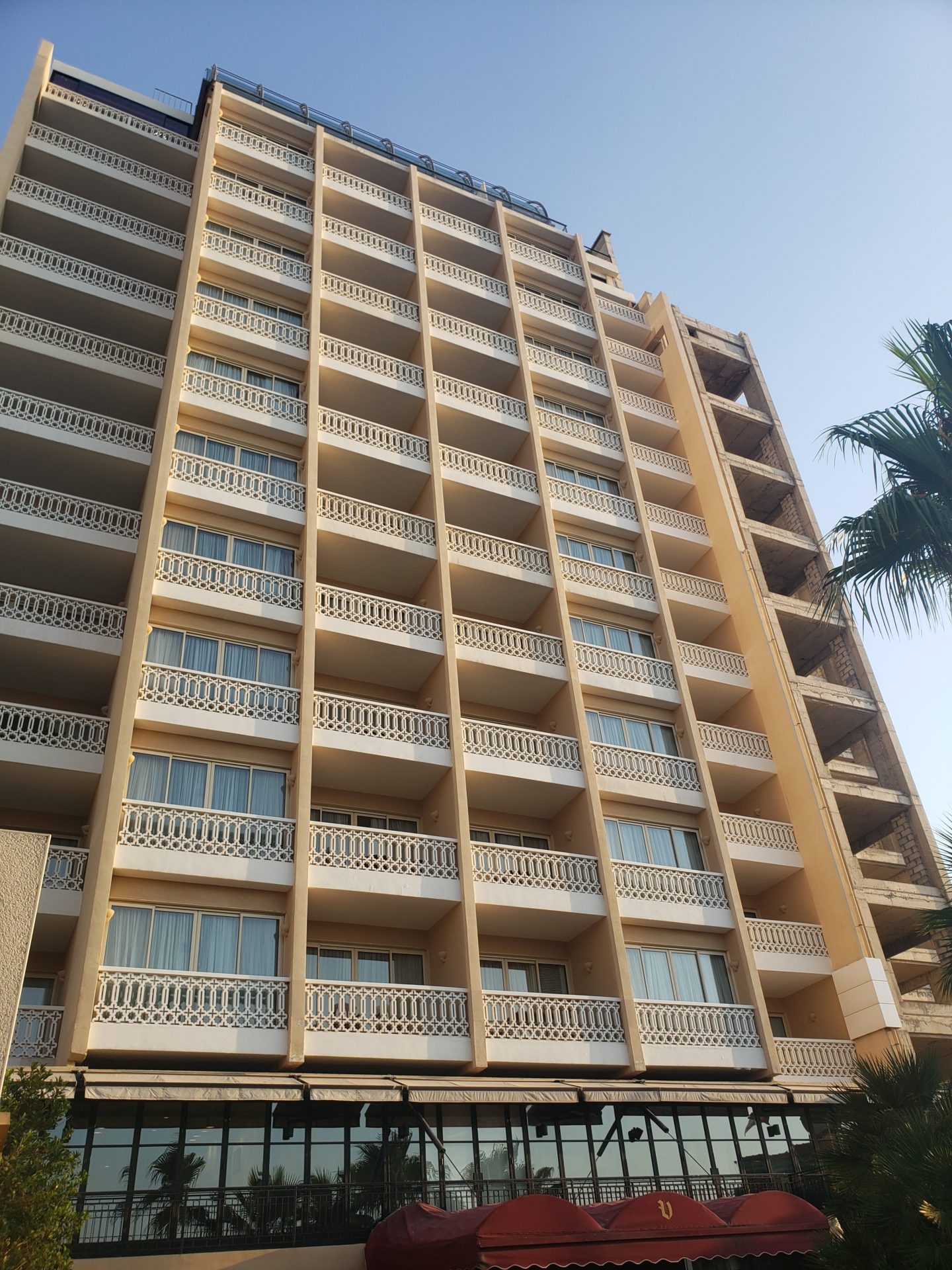 a building with balconies and palm trees