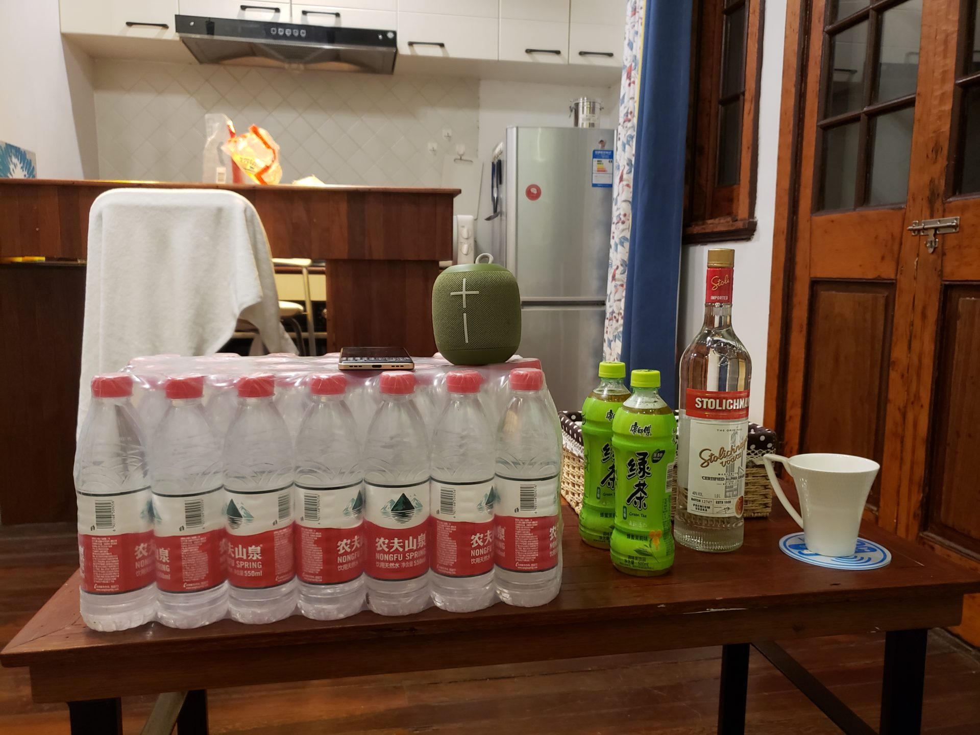 a table with bottles of liquid and a cup