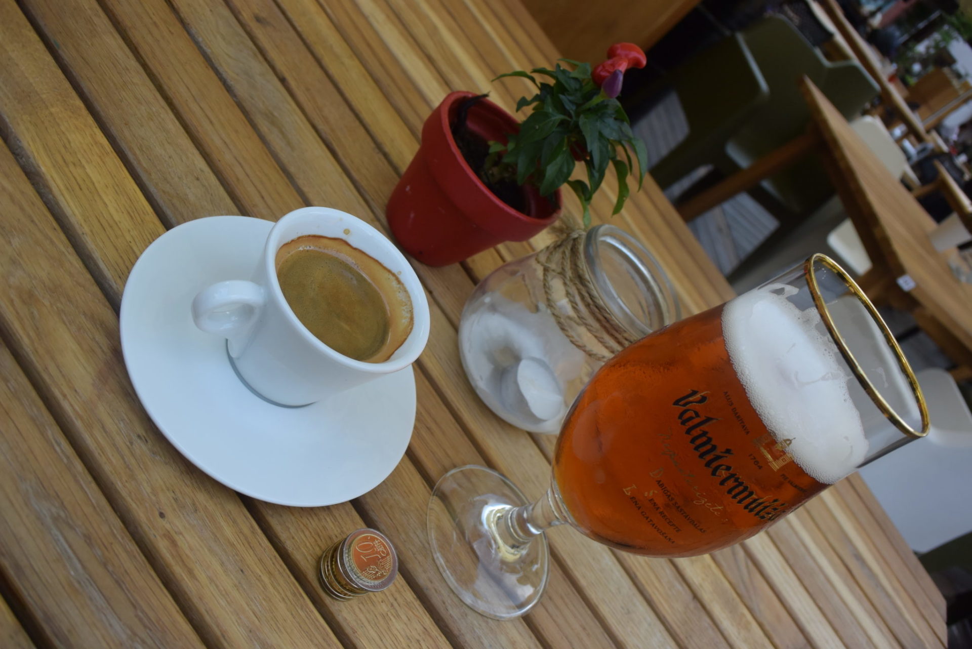 a glass of beer and a cup of coffee on a table