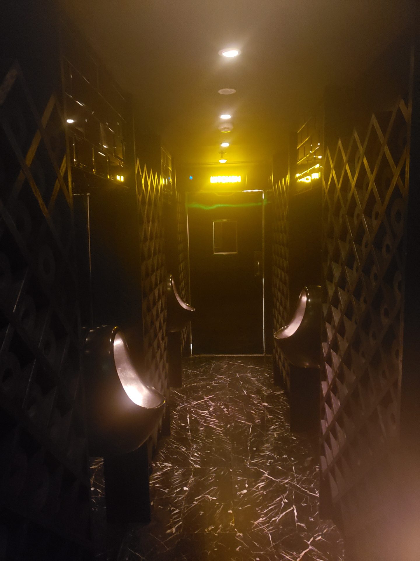 a dark hallway with urinals