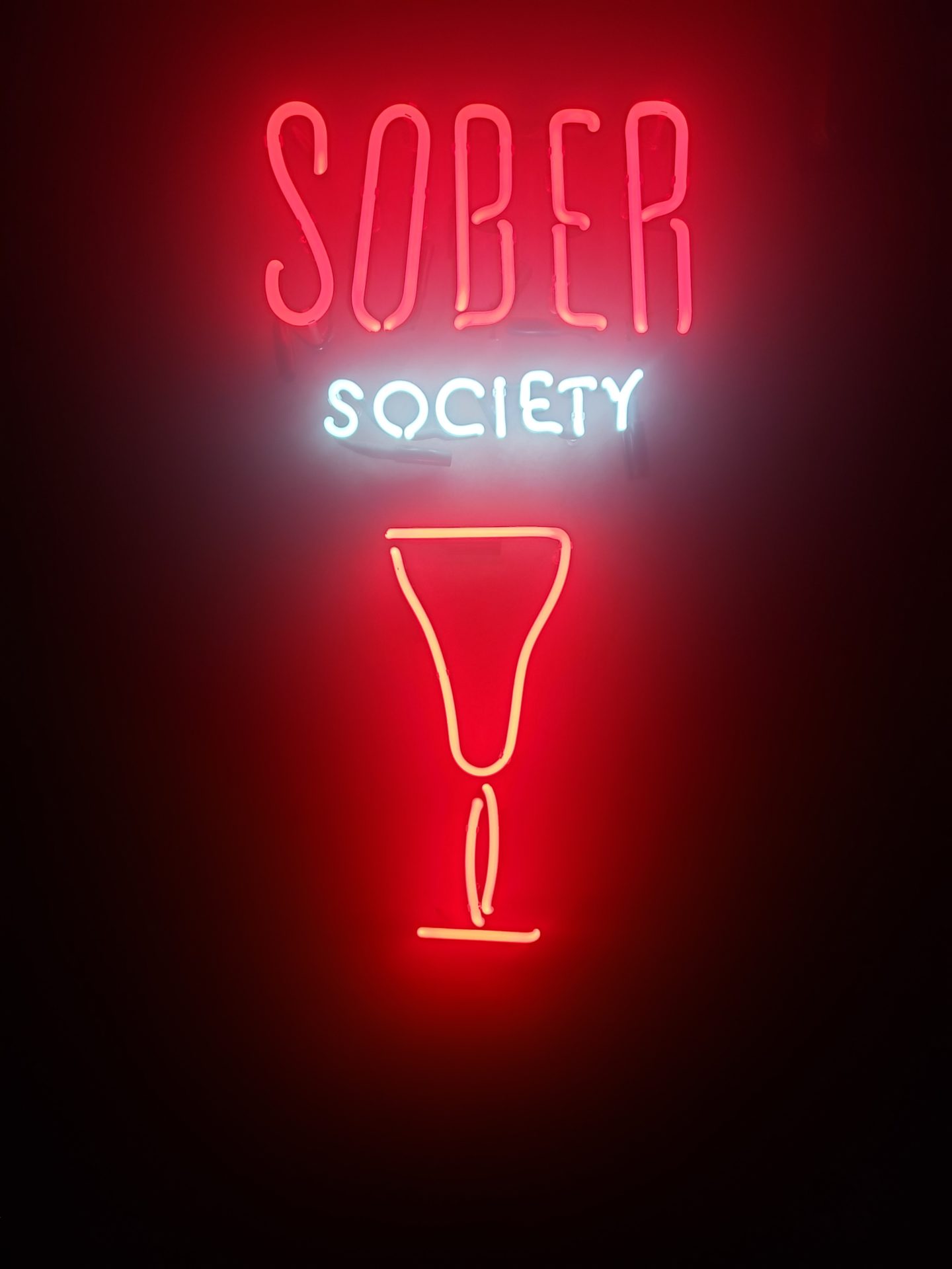 a neon sign with a glass of wine