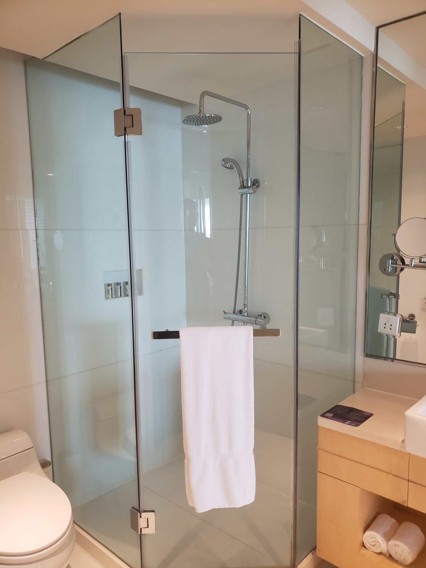 a shower with a white towel from the glass door
