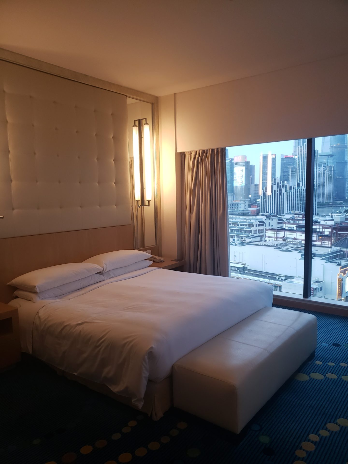 a bed in a room with a window and city view