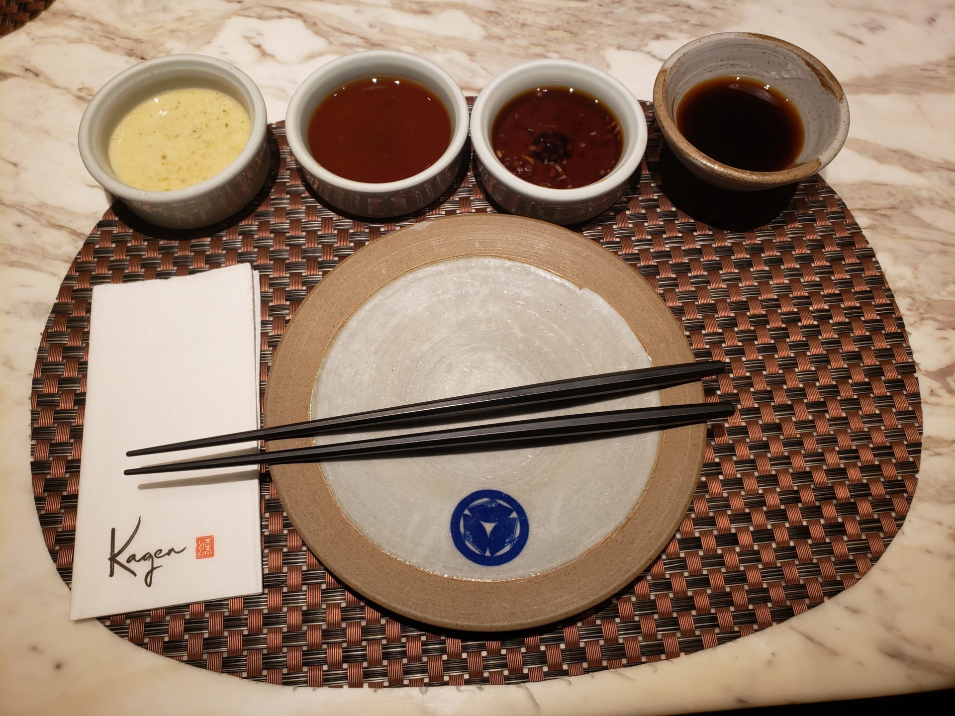 a plate with different sauces and chopsticks on a table