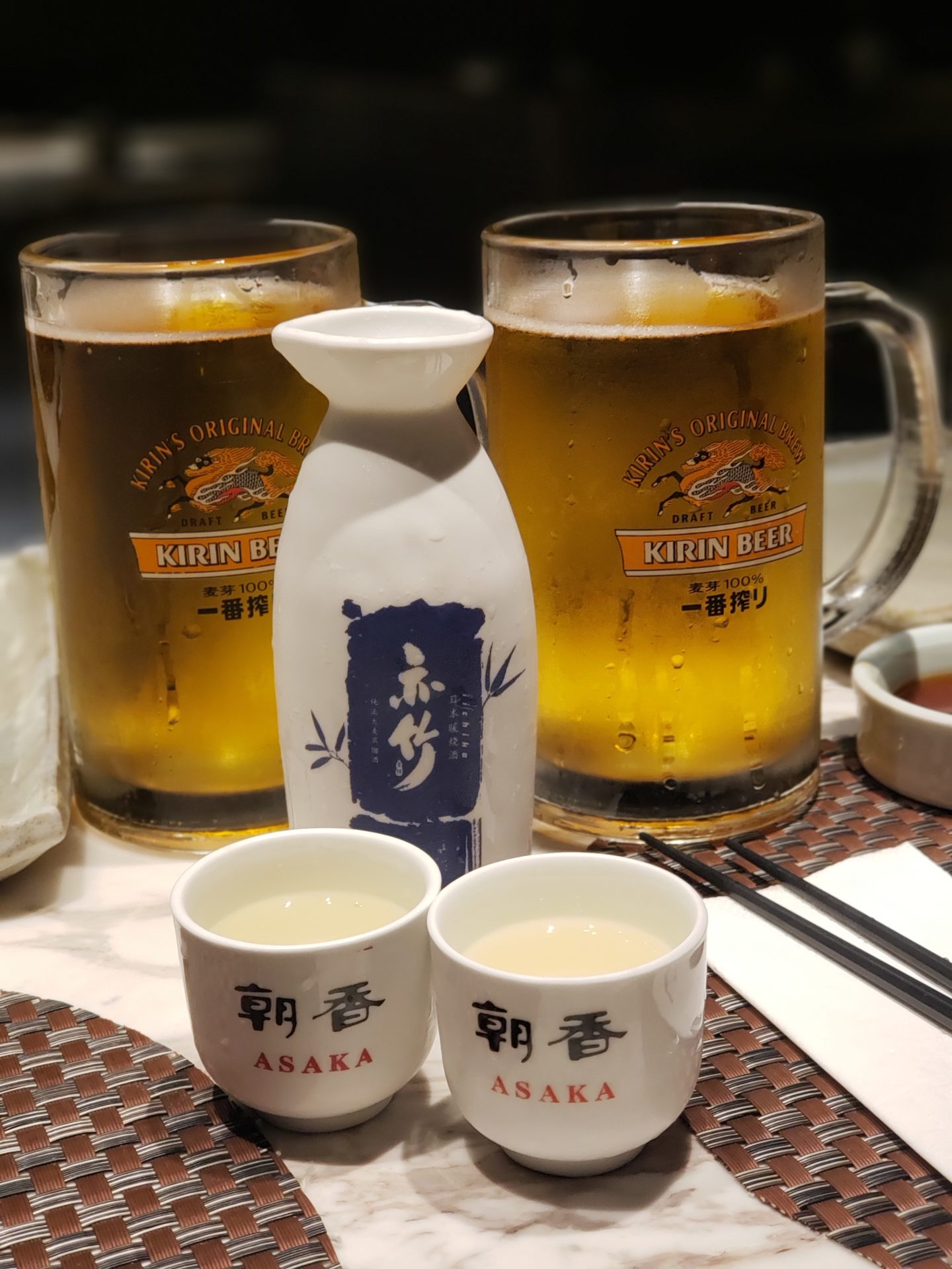 a bottle of sake and two cups of beer