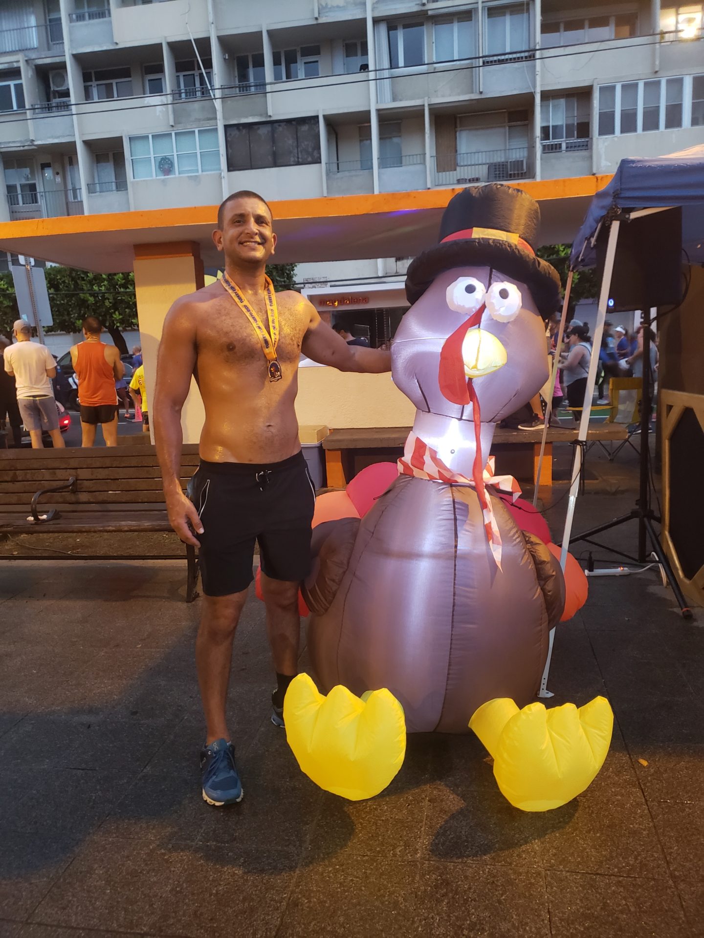 a man standing next to a large inflatable turkey