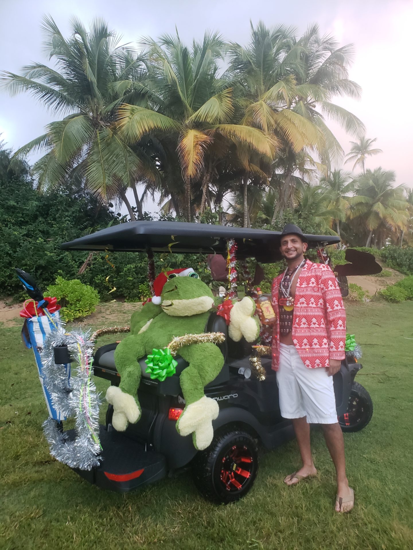 a man standing next to a golf cart with a stuffed animal