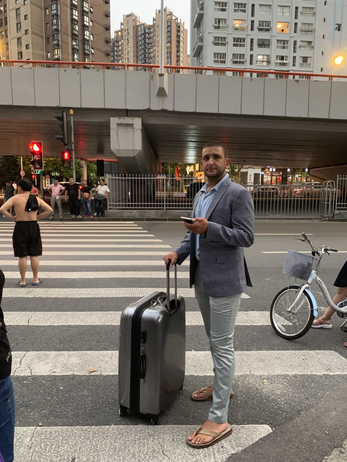 a man holding a suitcase standing on a street