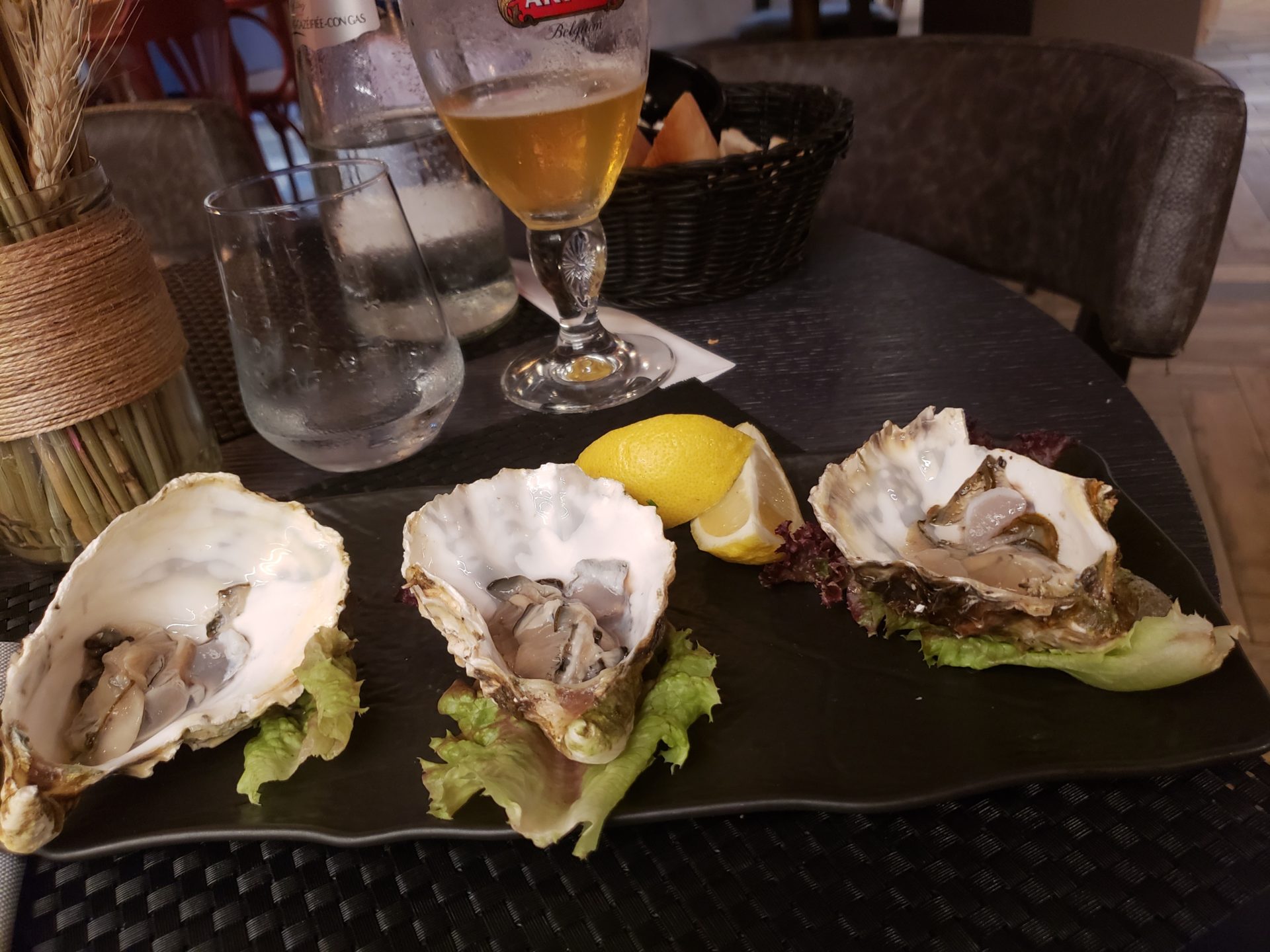 a plate of oysters and lemons on a table