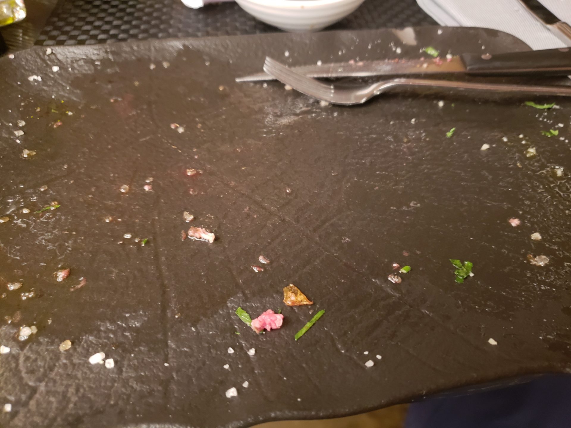 a dirty plate with food crumbs and a fork