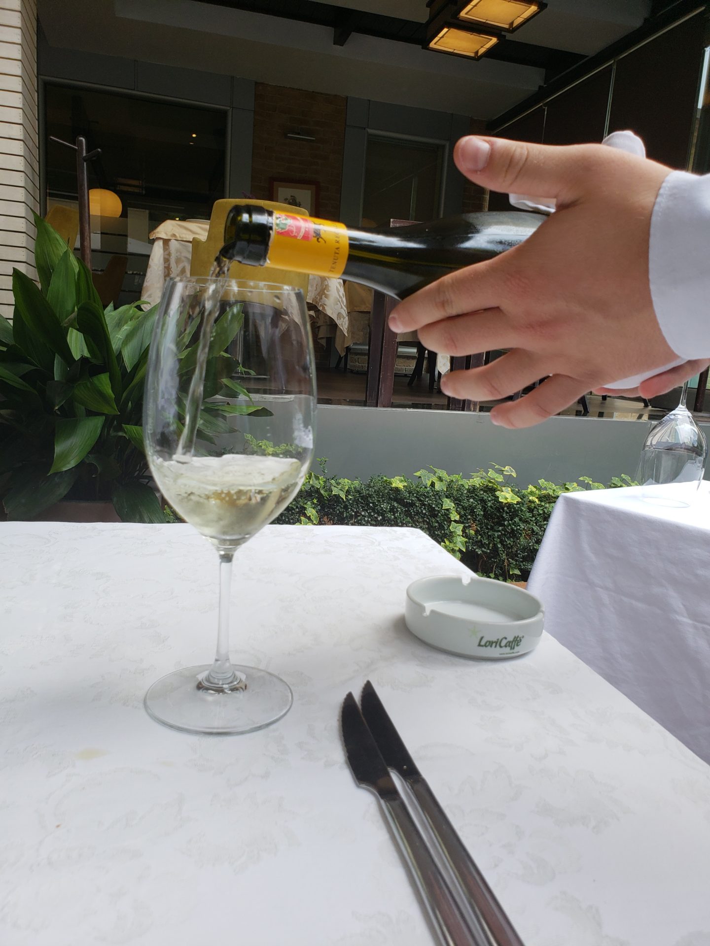a person pouring a wine into a glass