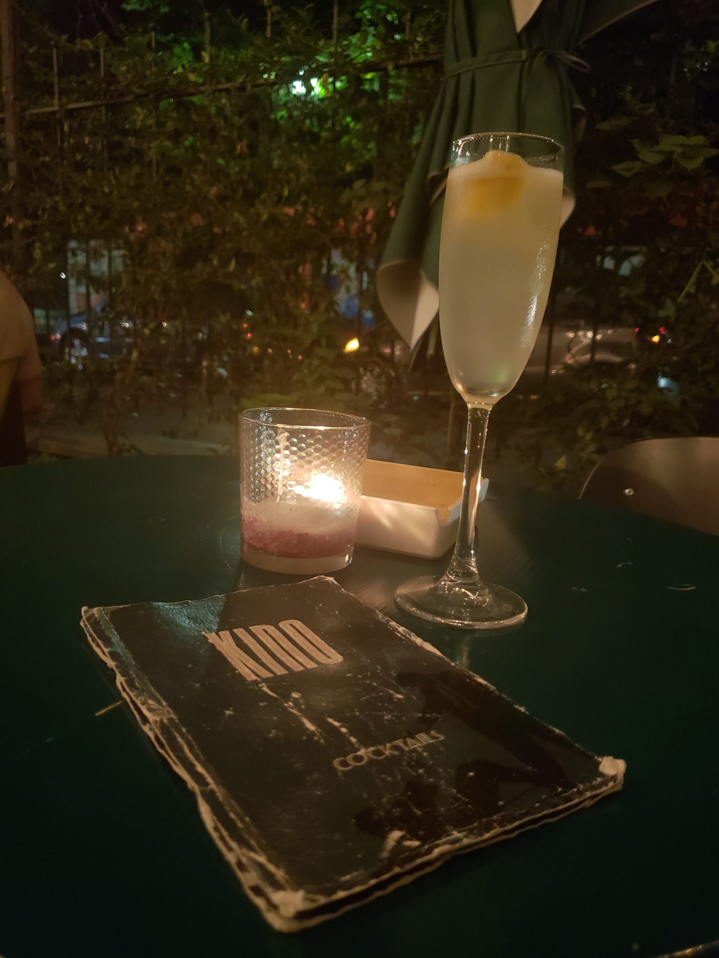 a glass of liquid and a book on a table