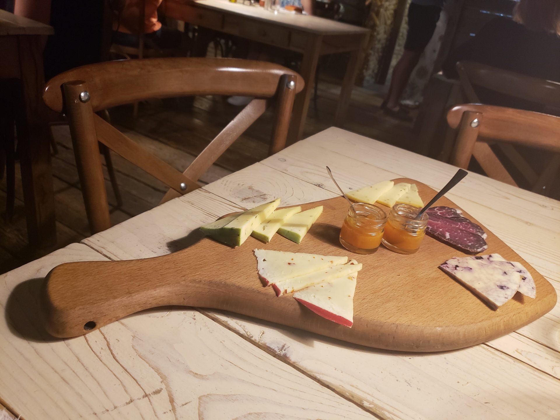 a board with cheese and jams on it