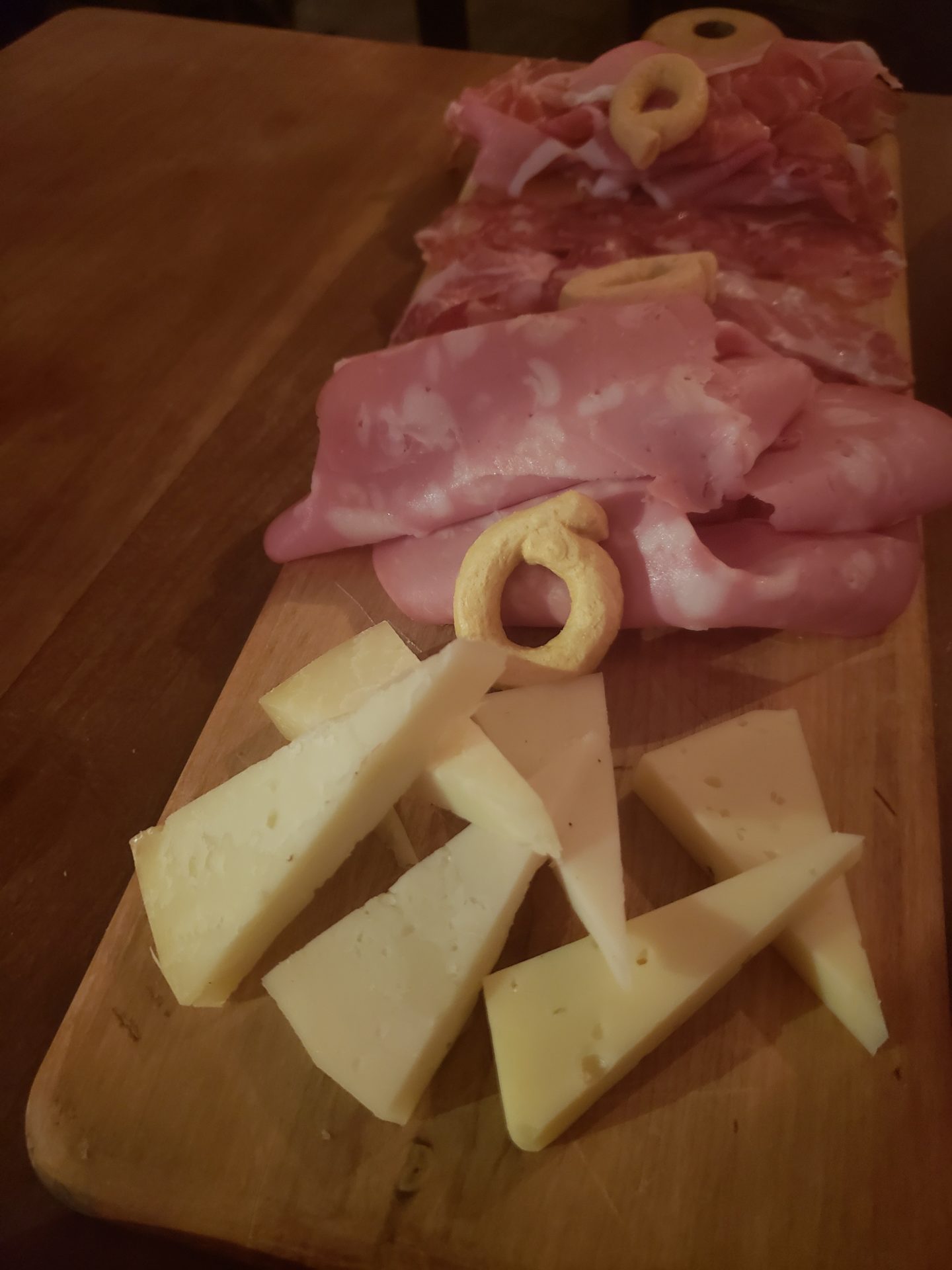 a cutting board with different types of meat and cheese
