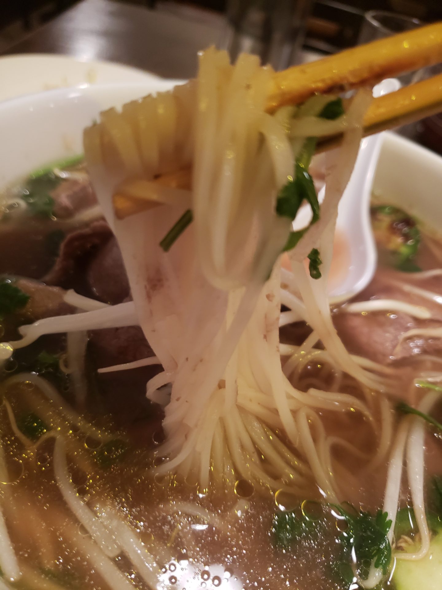 a bowl of soup with chopsticks
