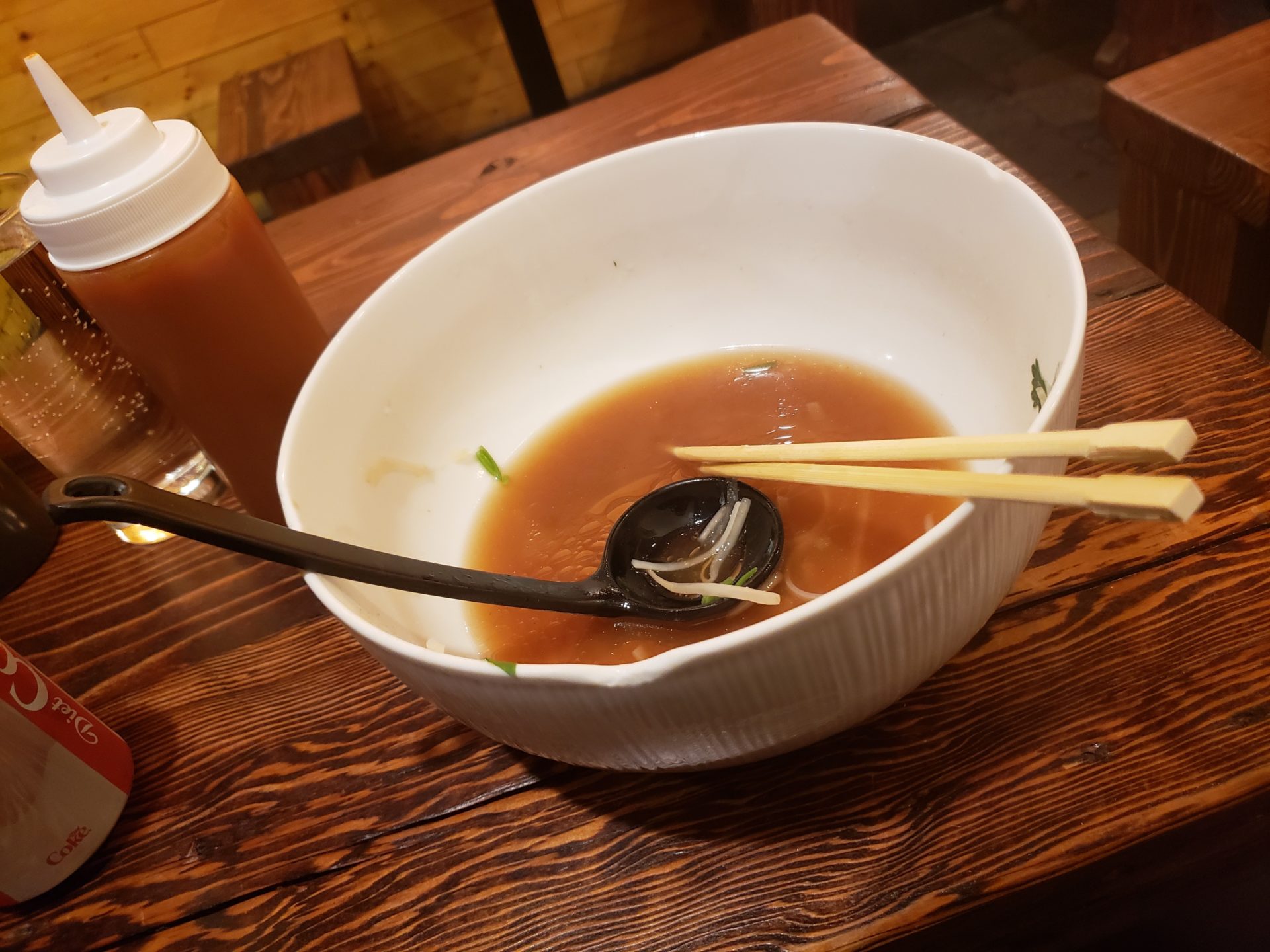 a bowl of soup with chopsticks and a spoon