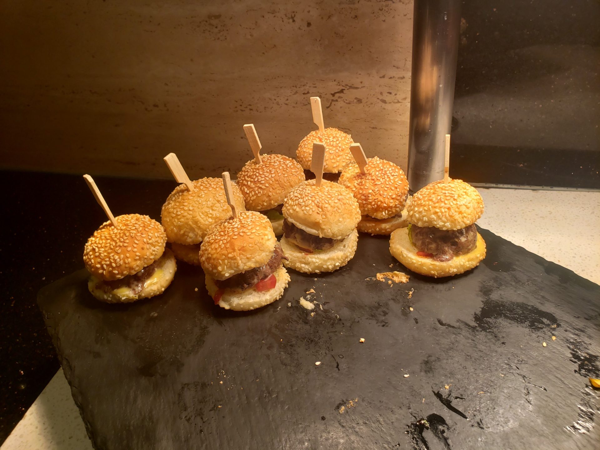 a group of mini burgers on a black surface