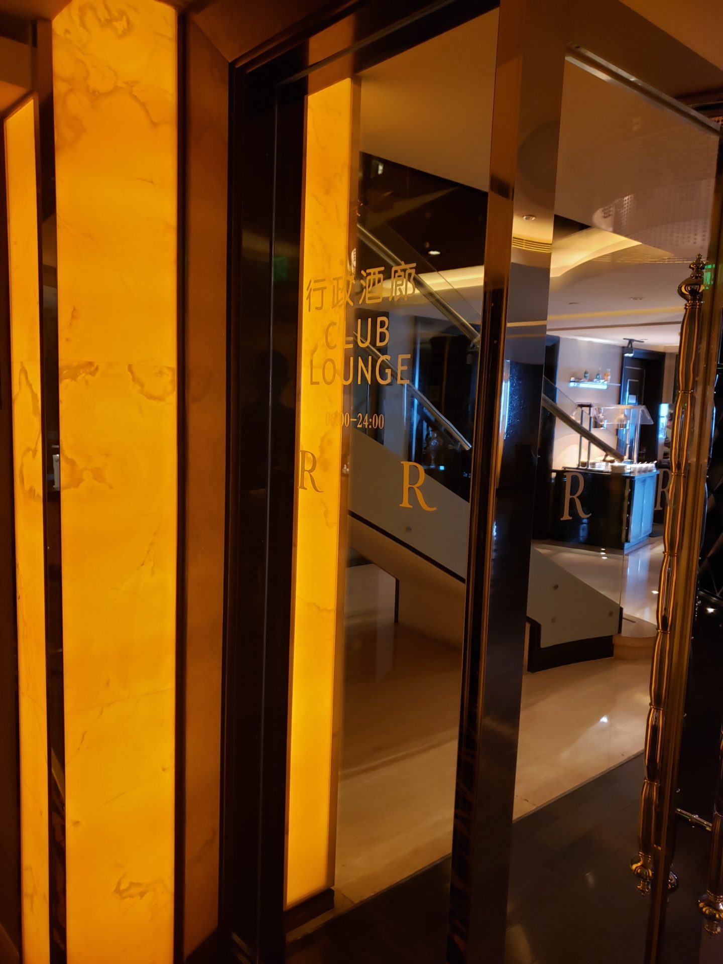 a glass door with gold and black text