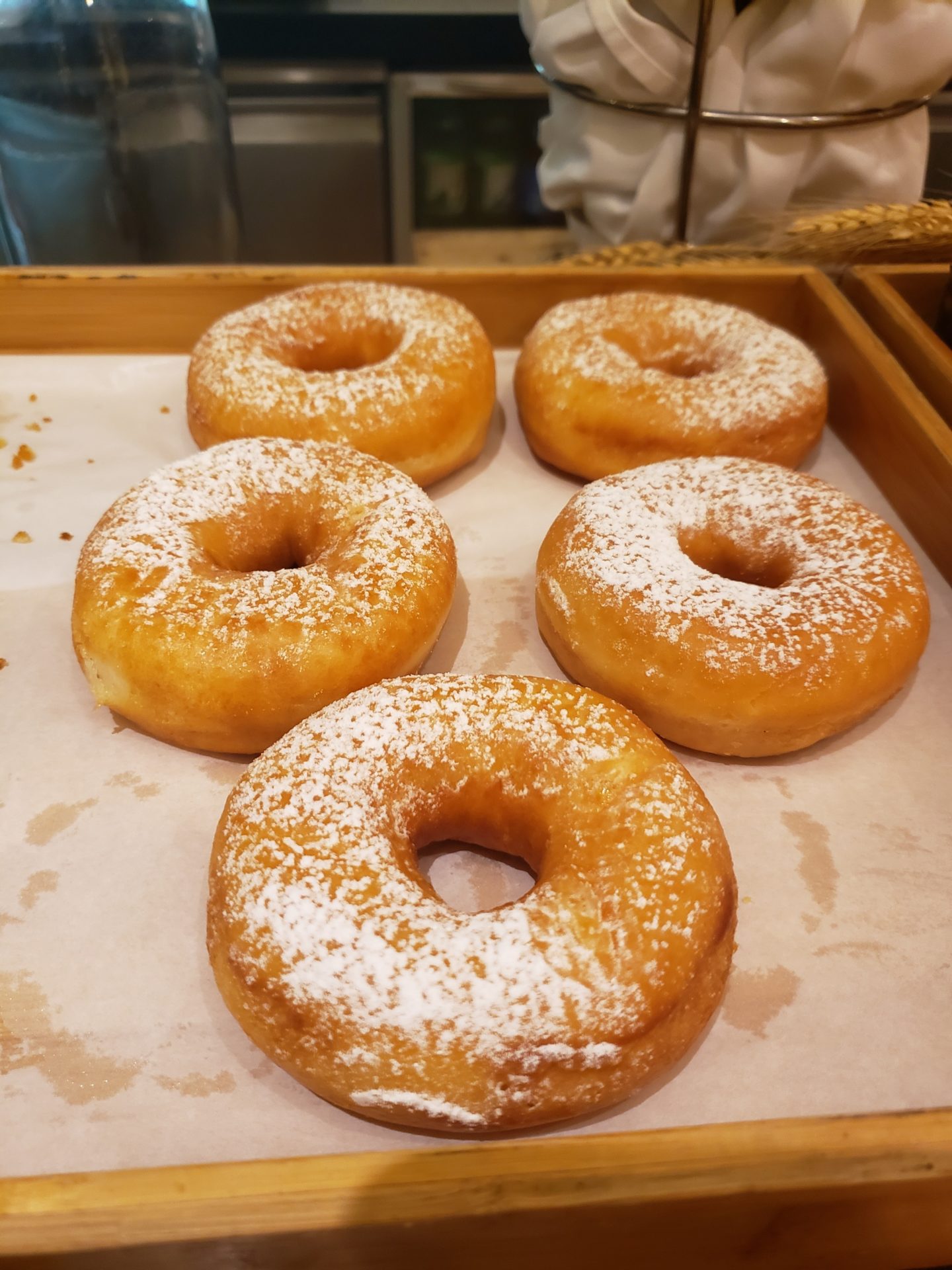 a tray of donuts with powdered sugar