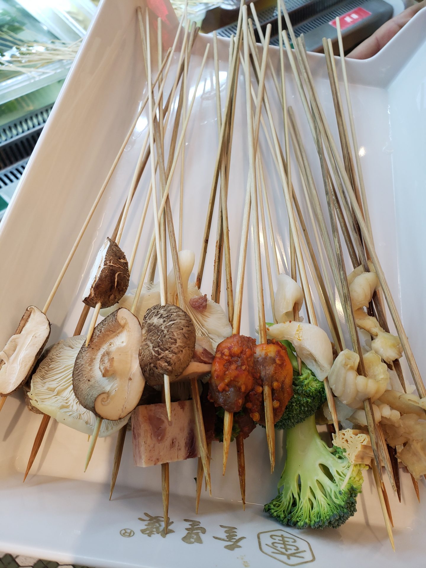 skewers with meat and vegetables on them in a white tray