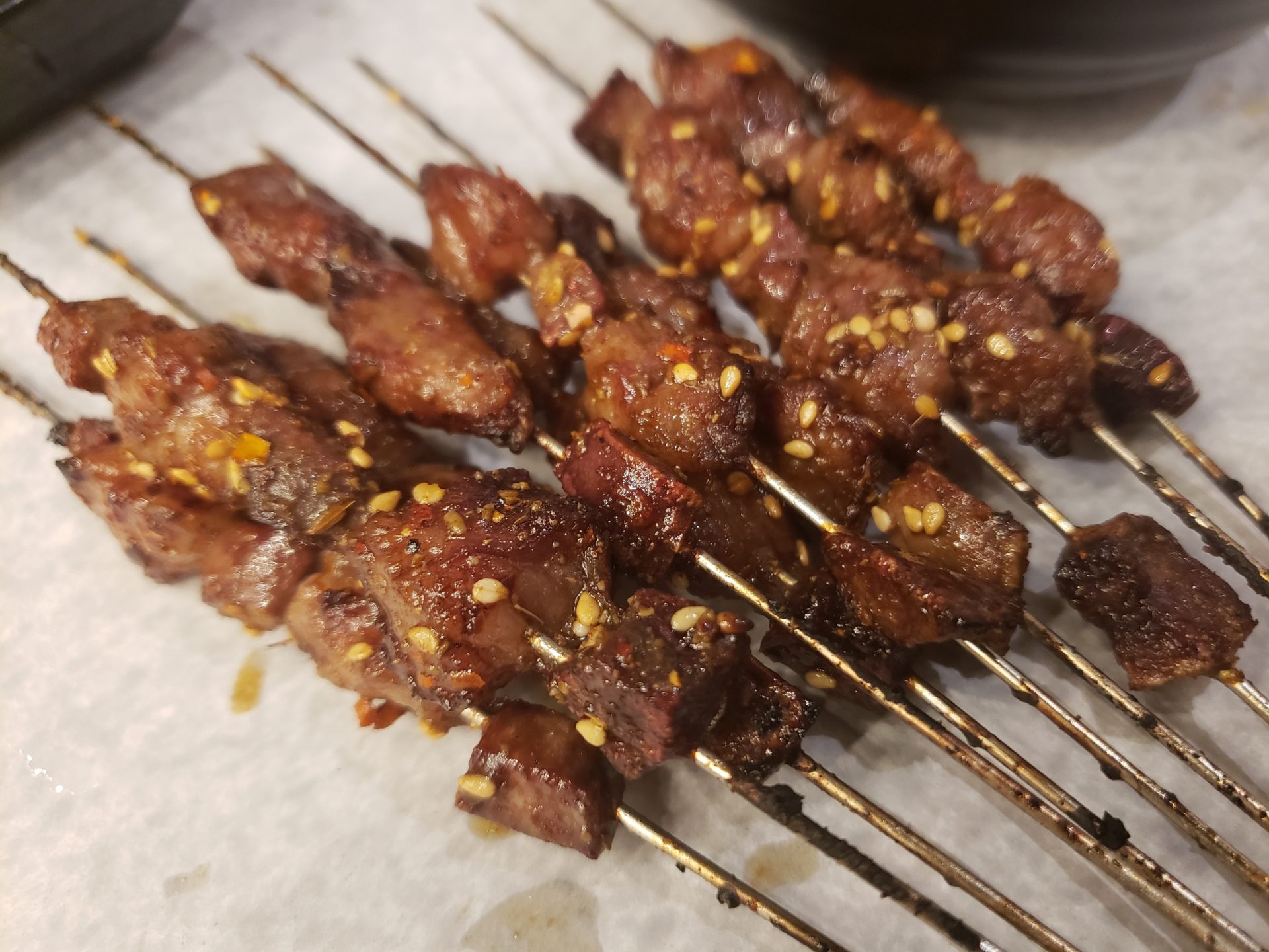 skewers of meat on a white surface