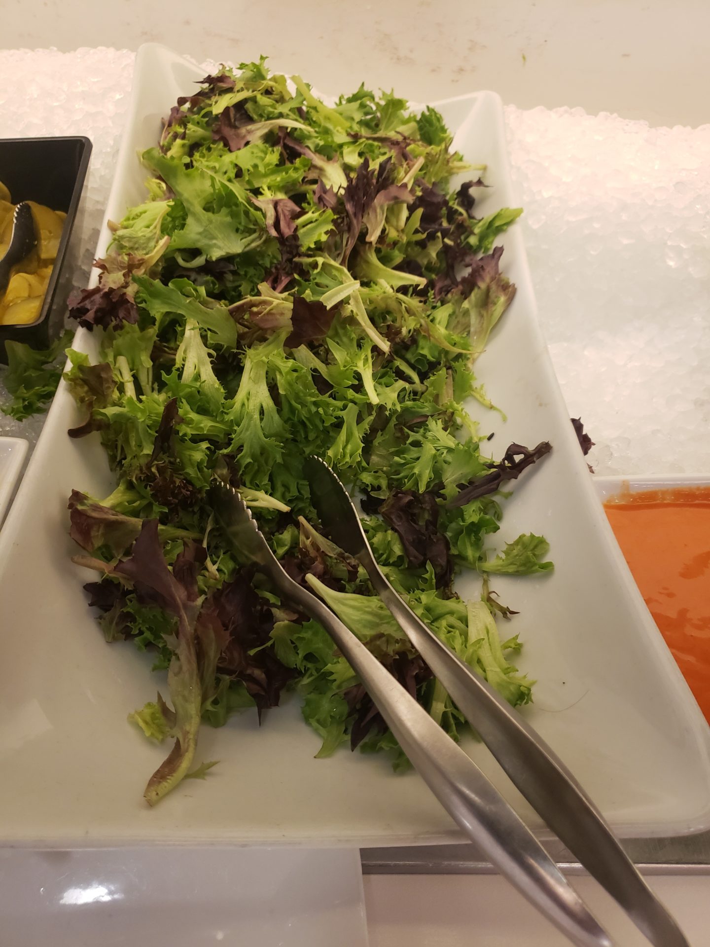 a plate of salad with utensils