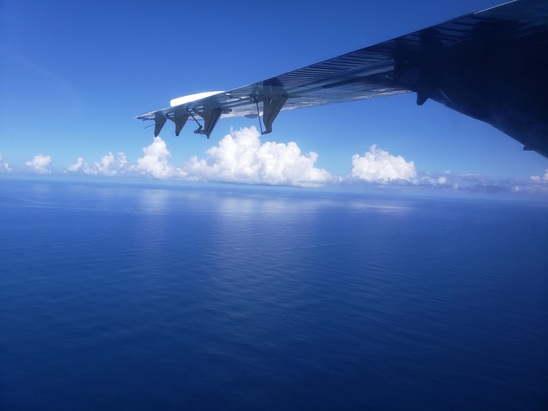 an airplane wing over the ocean