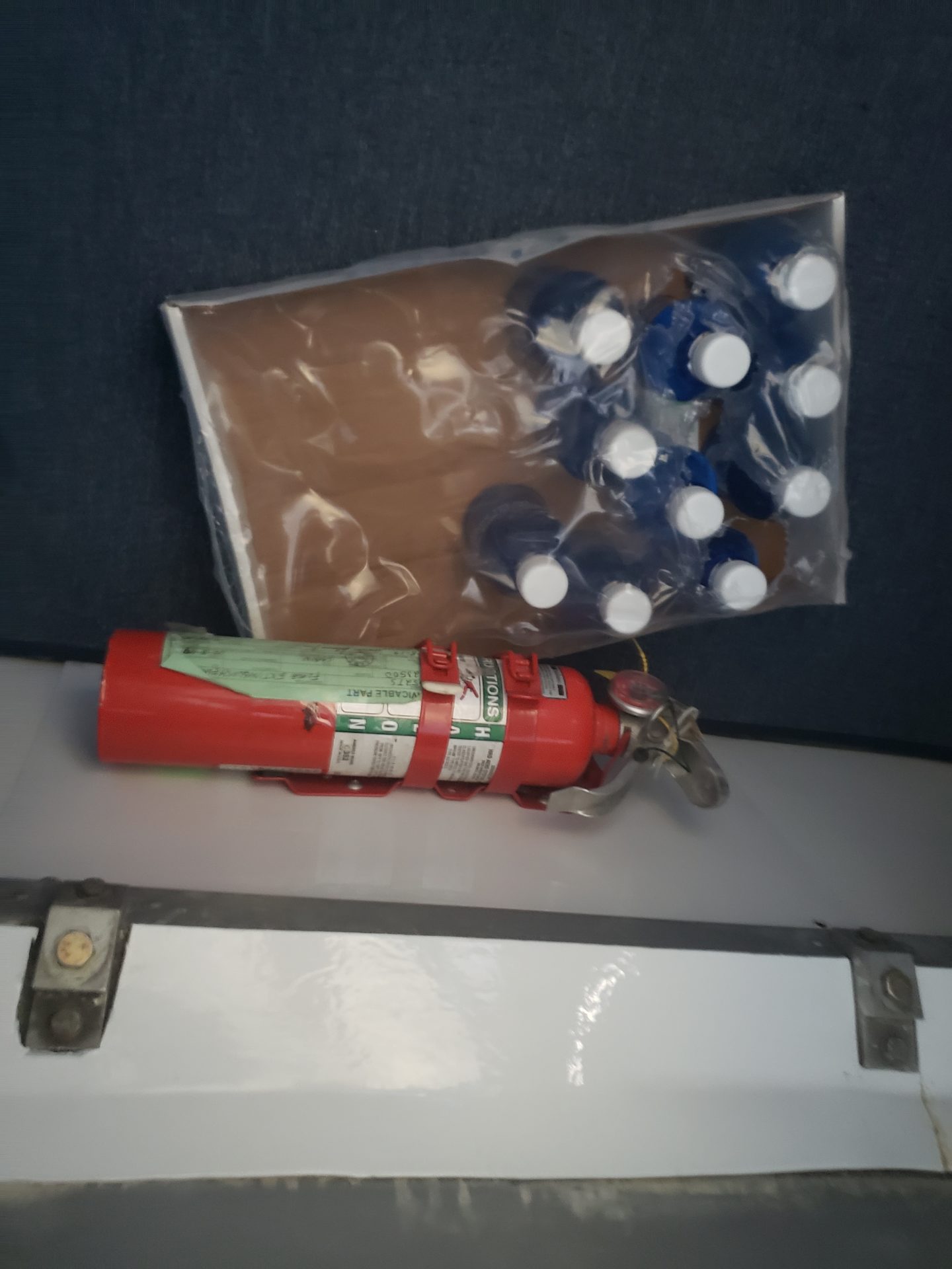 a fire extinguisher and a bag of blue and white bottles