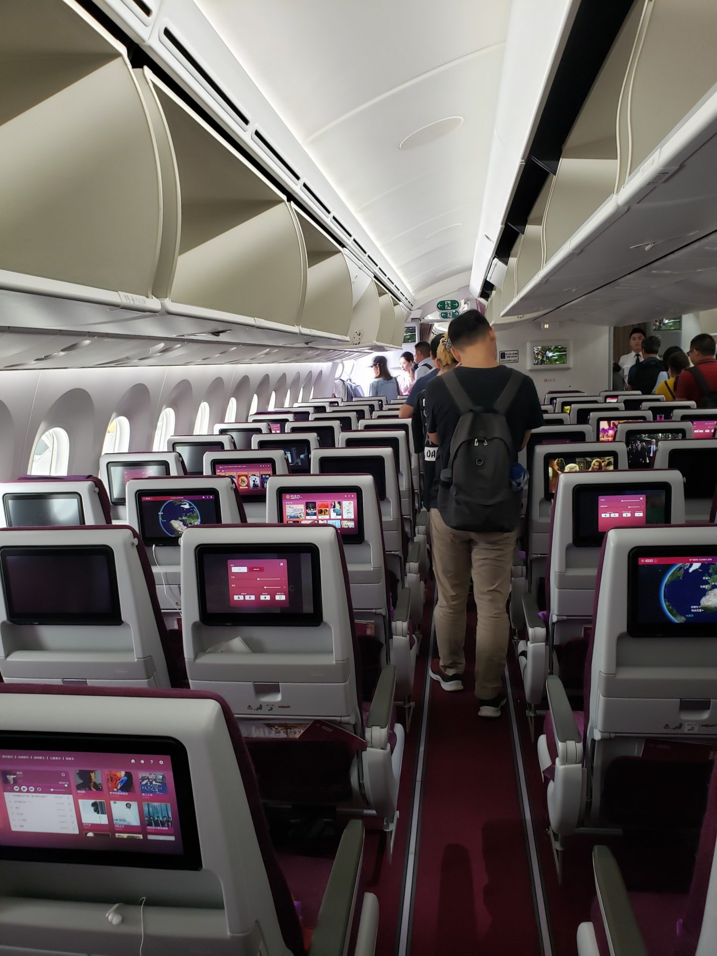 a man walking in an airplane with many monitors