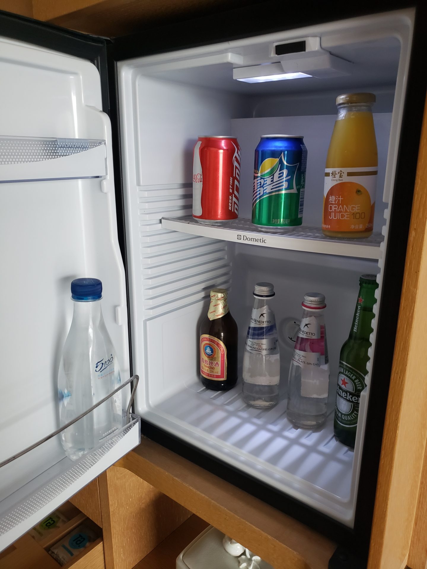 a refrigerator with bottles of soda and cans