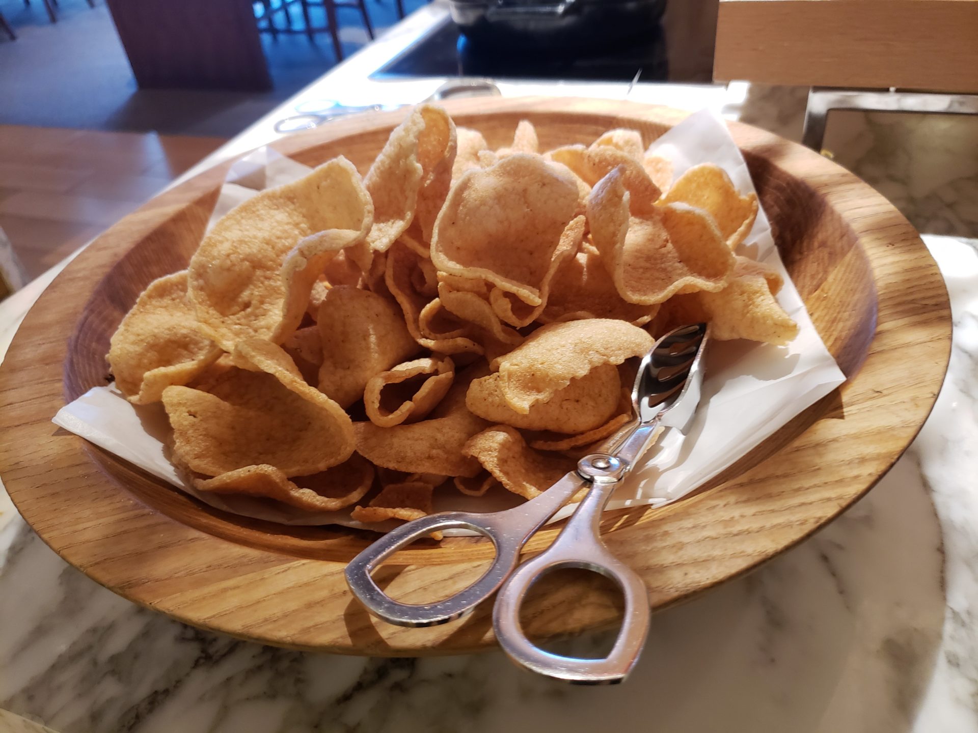 a bowl of potato chips and scissors