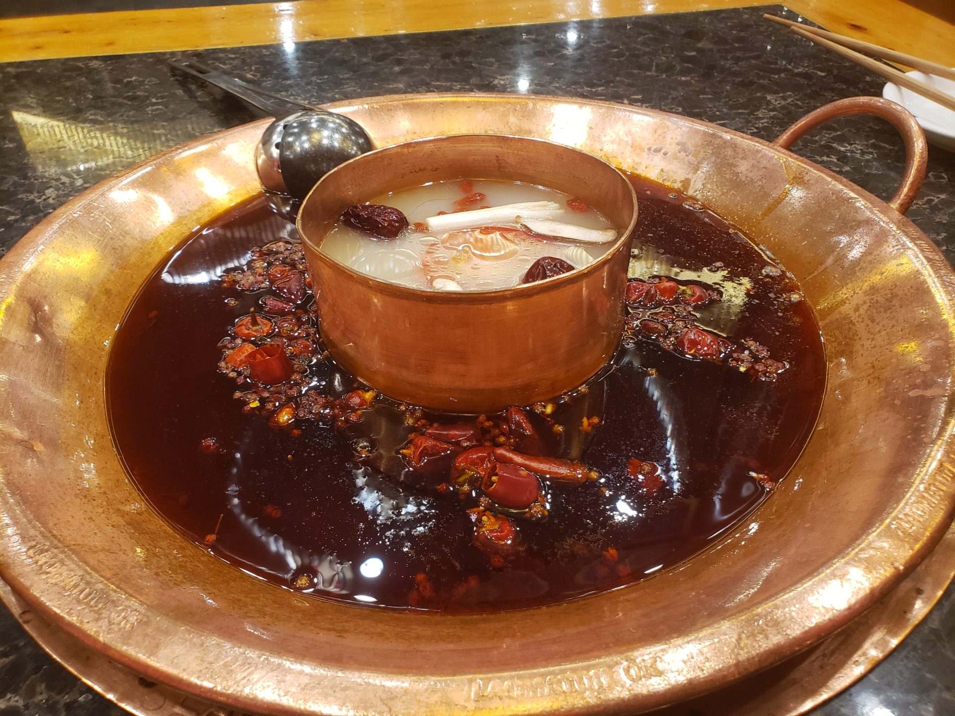 a copper pot with a soup in a copper bowl