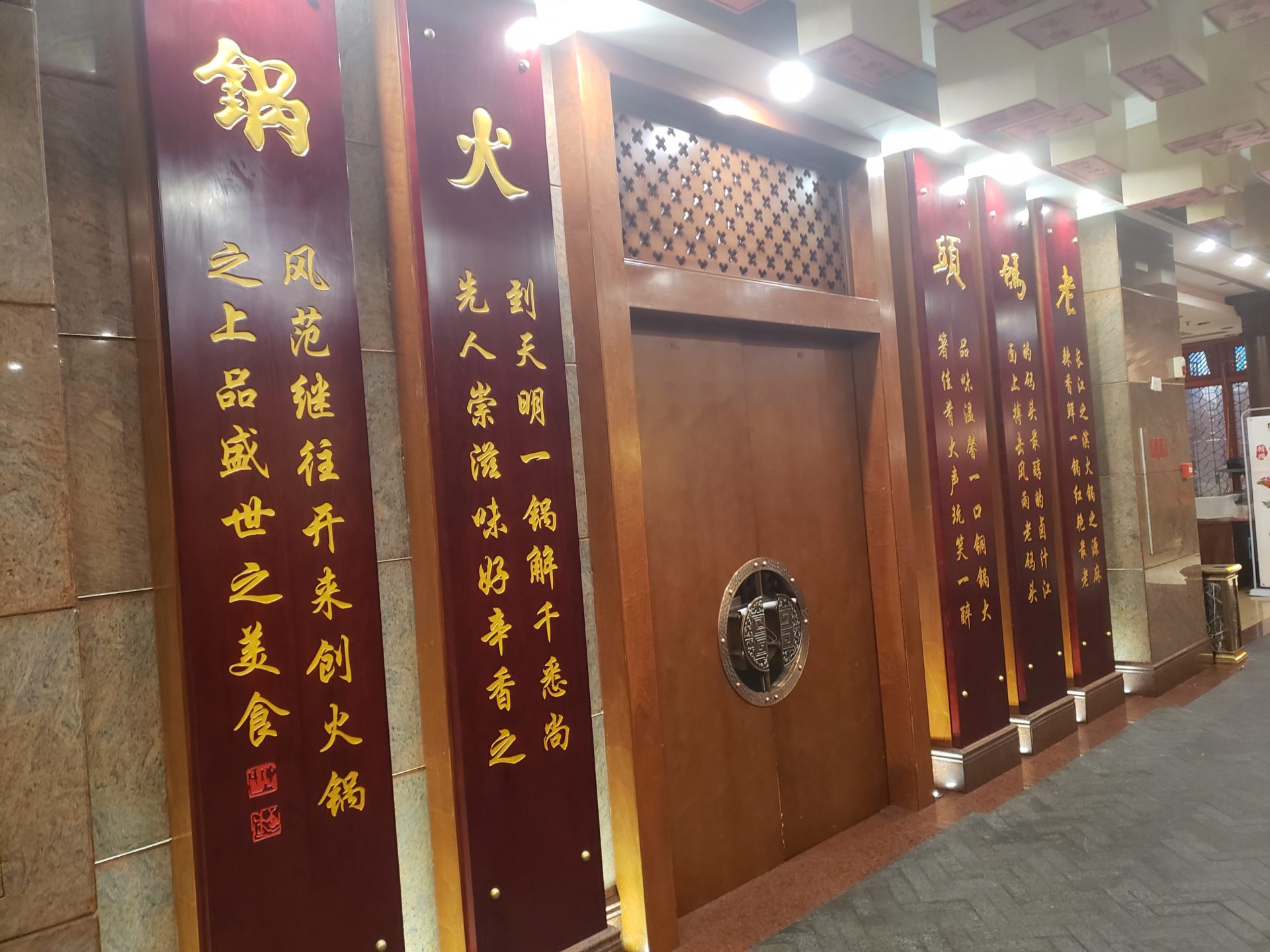 a long wooden door with gold writing on it