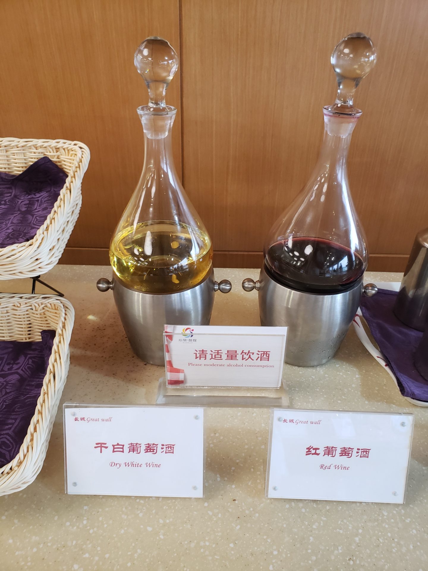 a glass decanters with liquid in them and a container with name cards
