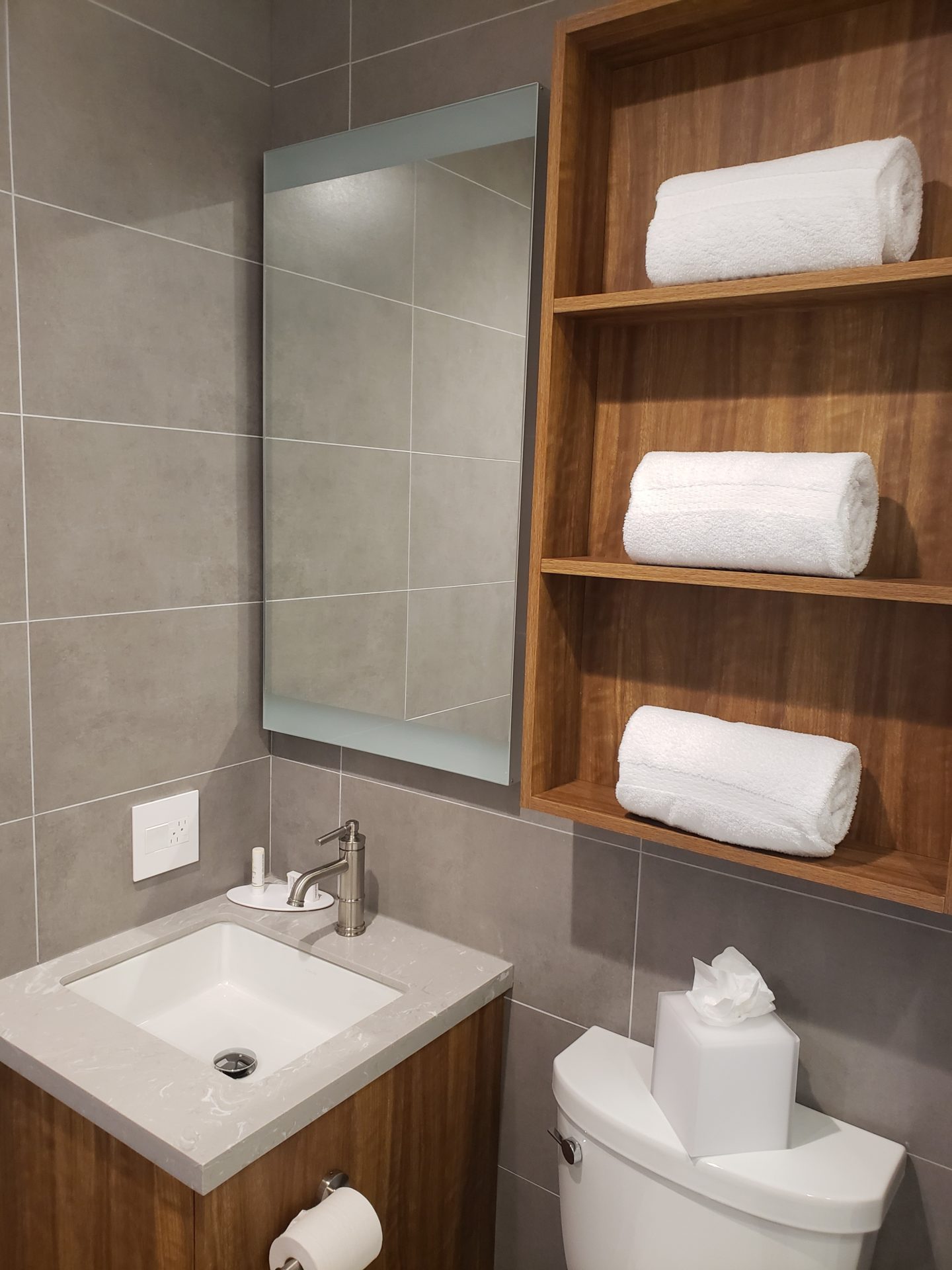 a bathroom with a sink and a shelf with towels
