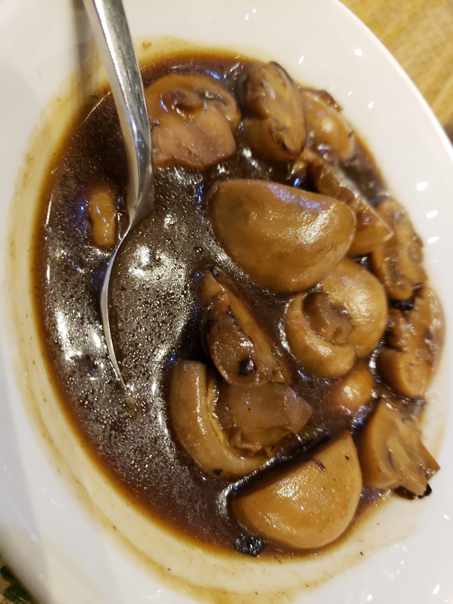 a bowl of brown sauce with mushrooms