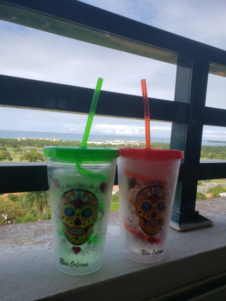two cups with straws on a ledge