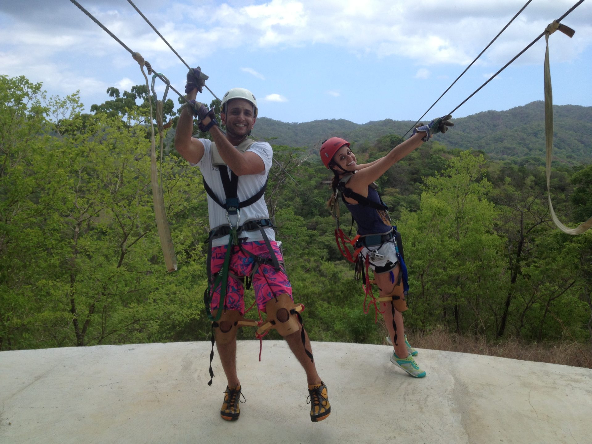 a man and woman wearing safety harnesses and climbing ropes
